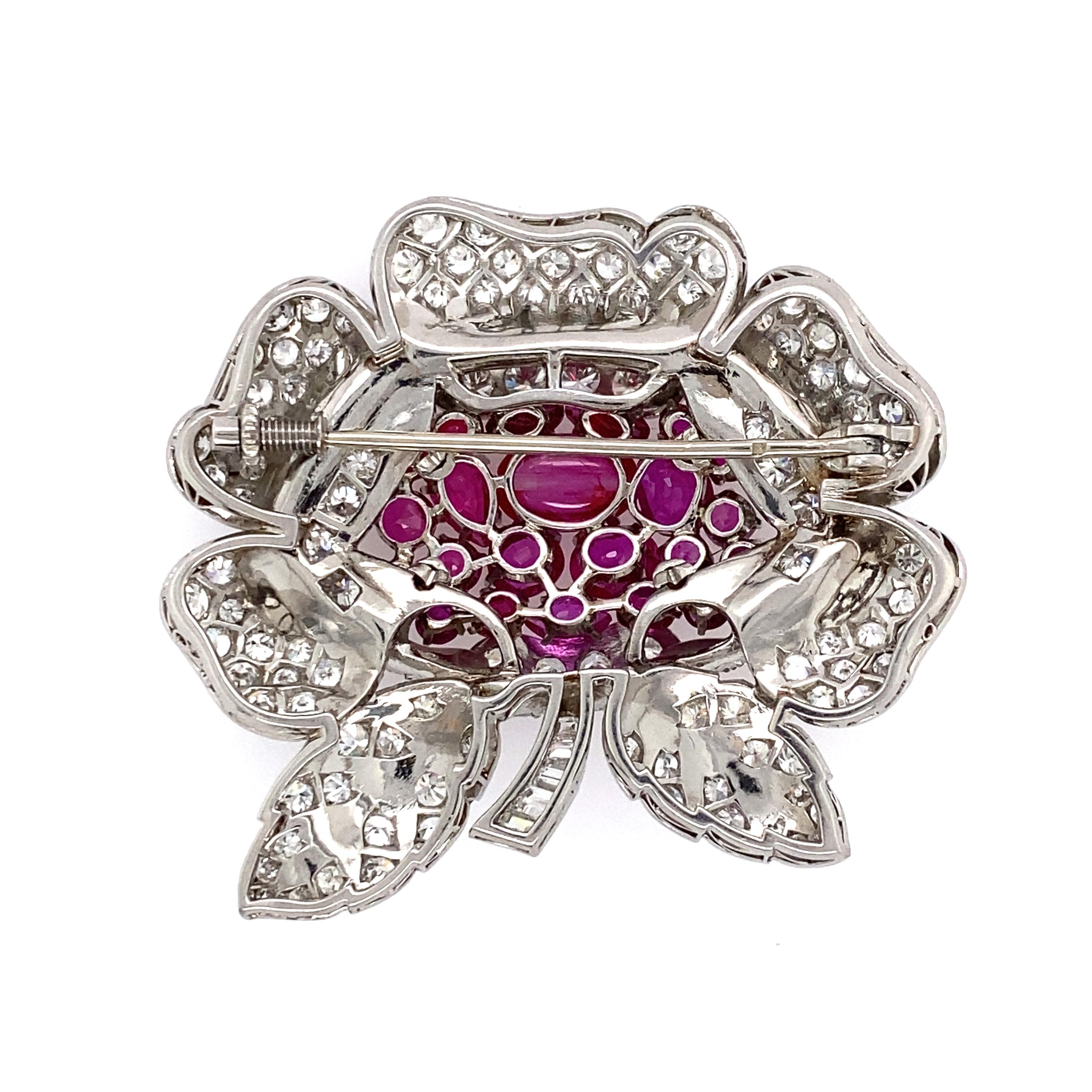 Fabulous French Art Deco platinum Burmese ruby and diamond mounted floral form pin. 22 color match Burmese rubies. Largest cabochon ruby measures approx. 8.5 x5.6mm. Center ruby chipped. Largest oval cut rub measures approx. 5.4 x4.3mm. marquis cut
