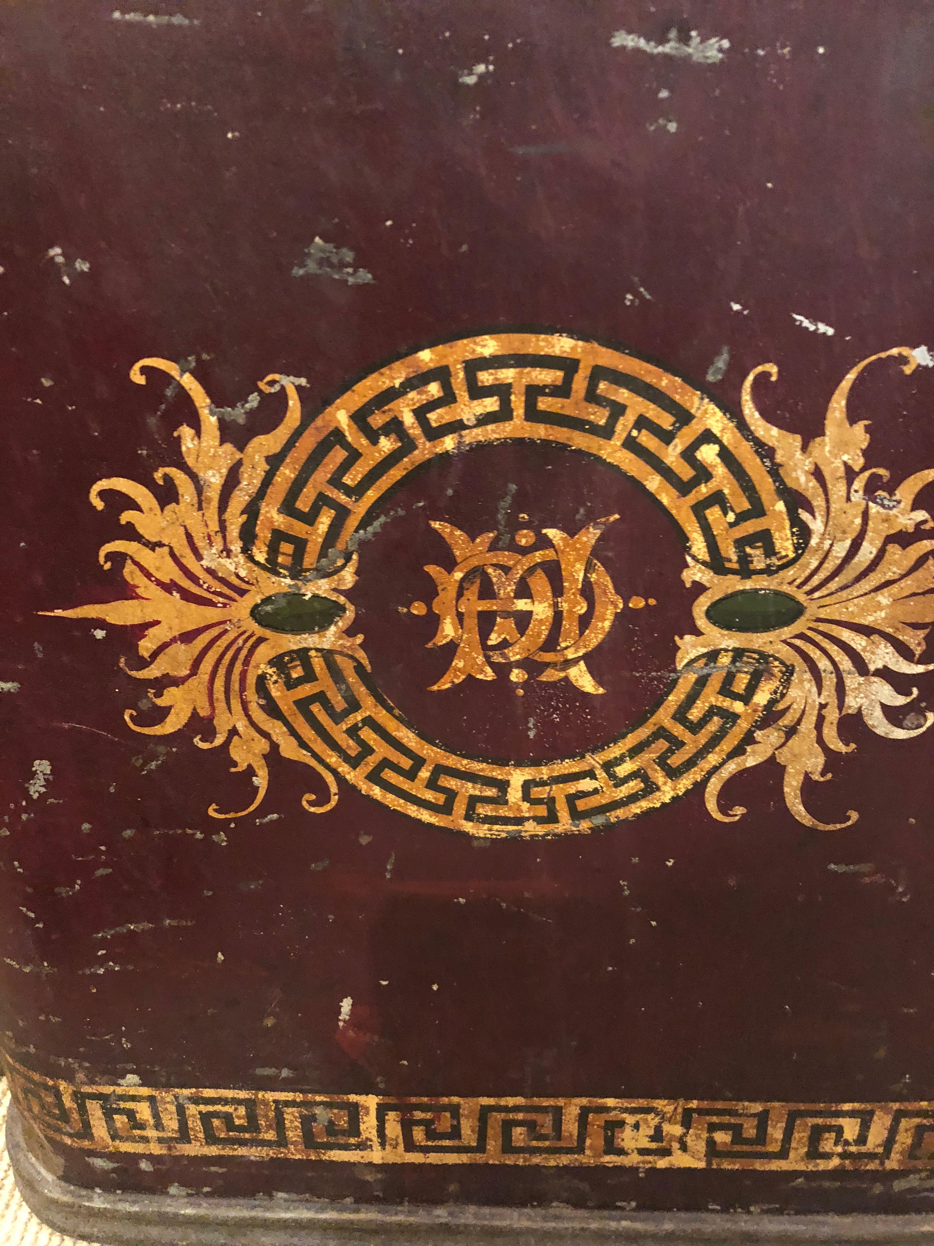 A fabulous large original antique toleware tea bin made by the famous Oolong Tea Company having graphic gold Greek key and neoclassical decoration, sliding top door and flat surface. Makes a super cool side or end table.
 