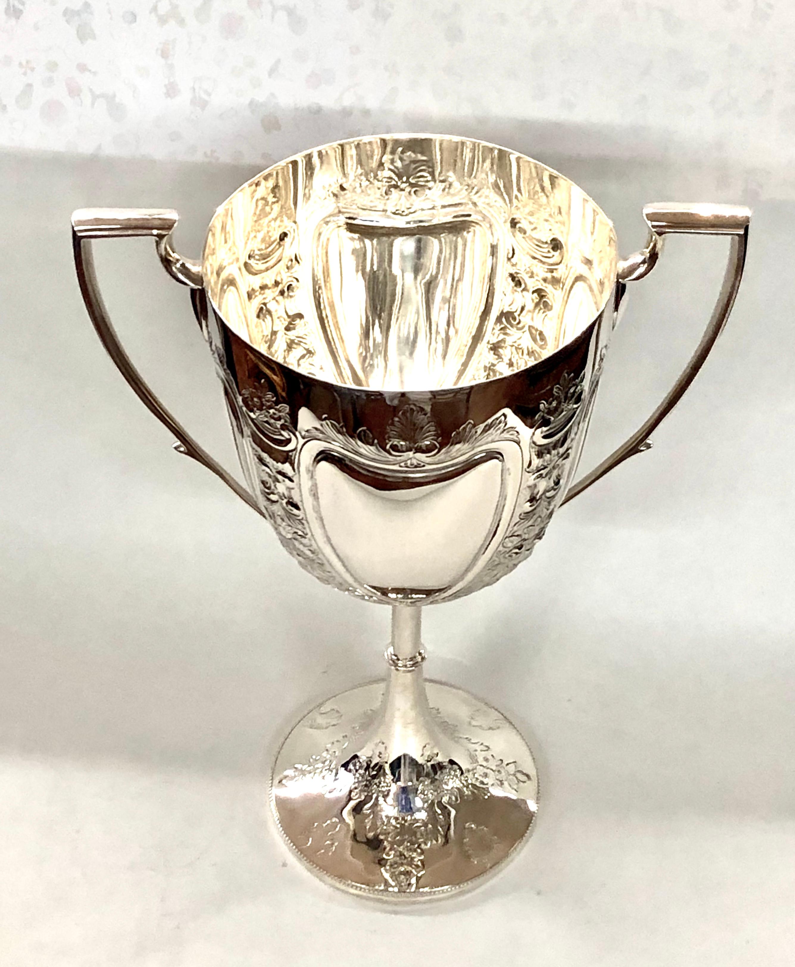 Fabulous antique English Sheffield silver plate trophy or loving cup with exceptional crisp hand chasing on cup and on base. Two large cartouches on either side suitable for engraving/inscribing. This is a monumental size suitable for a memorable