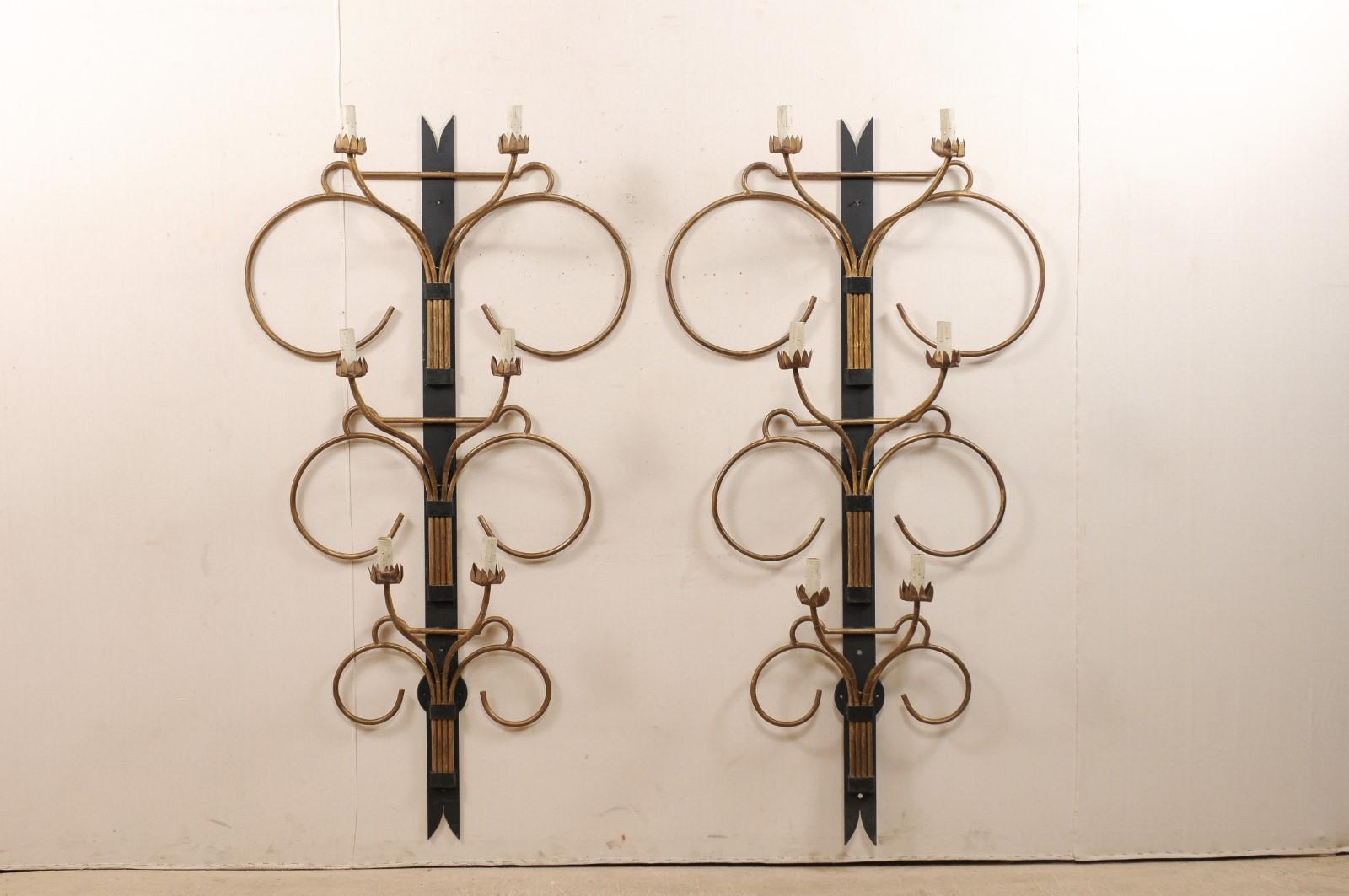 A fabulous pair of large-sized French Art Deco style sconces from the mid-20th century. These black and gold mid-century pair of sconces from France are impressively sized and just under 6 feet in height, and approximately 3 feet wide across their