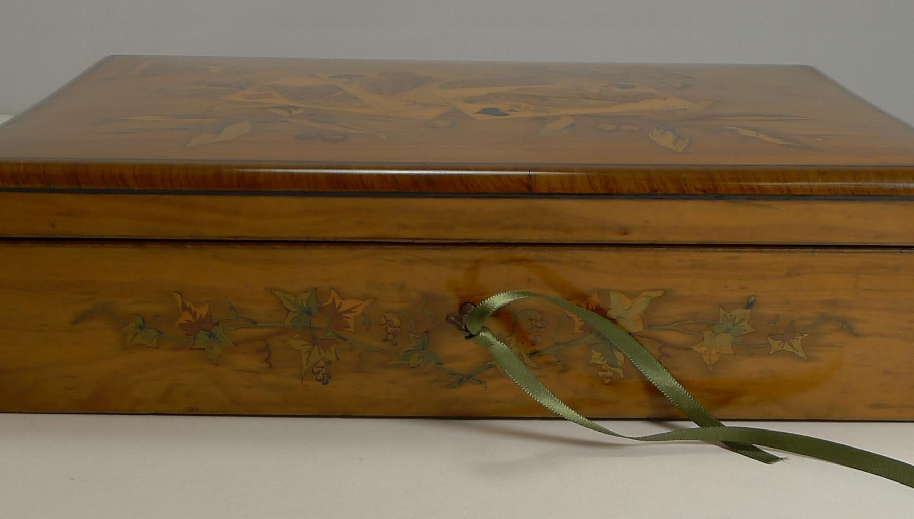 A truly stunning late Victorian playing card / games box made from beautiful olivewood with cross-banding to the edges and intricately inlaid with a suite of cards surrounded with olive branches; superbly executed.

This large box comes complete