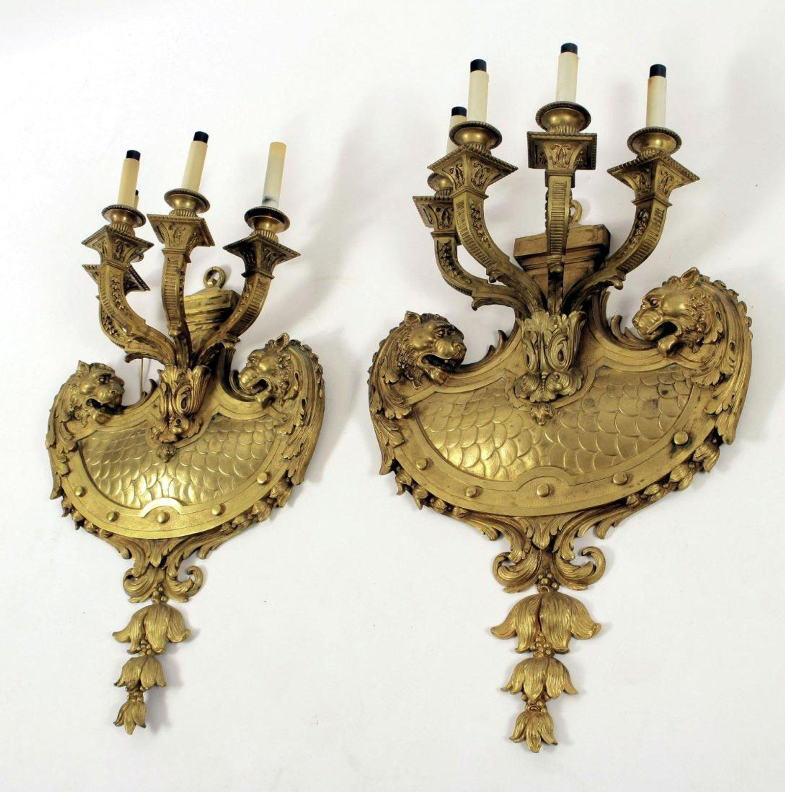 A massive pair of excellent quality doré bronze four arm sconces featuring lion's faces and interlaced 