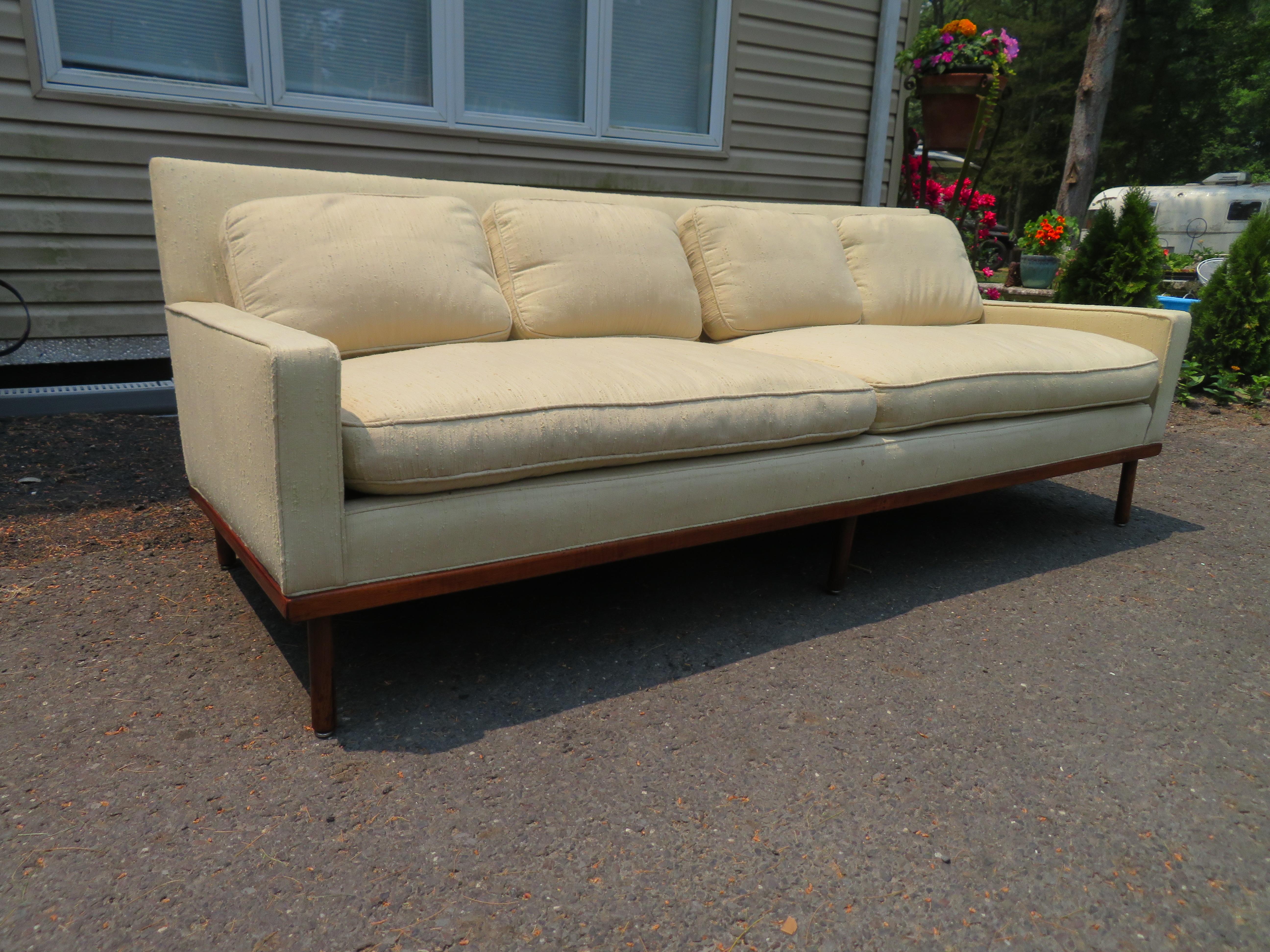 Fabulous Milo Baughman style walnut base sofa. The original white nubby fabric is in presentable vintage condition and could be used as is. This piece measures 30