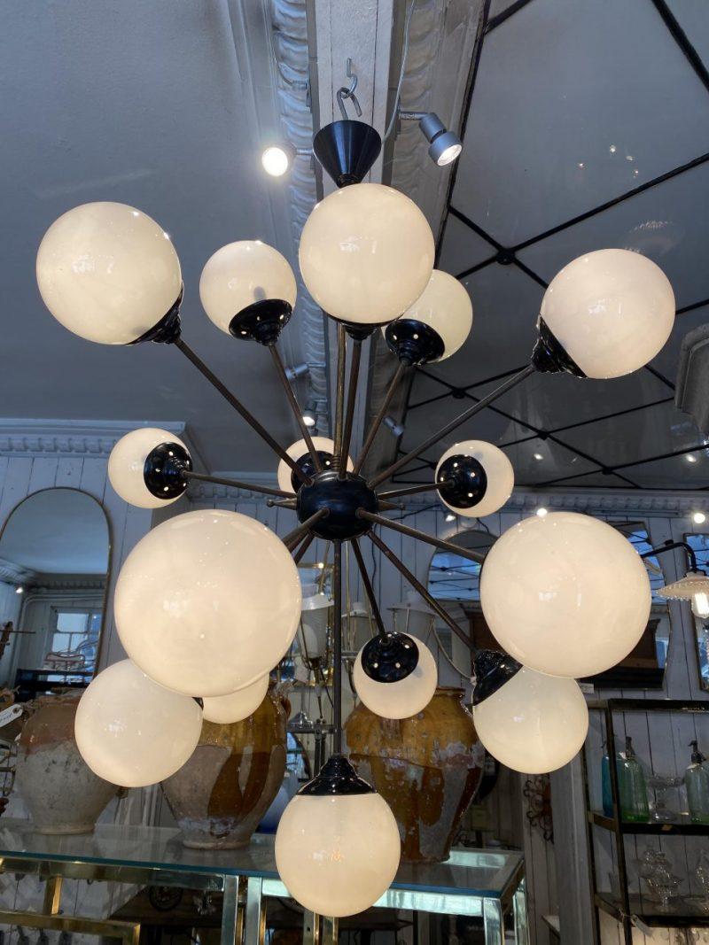 Beautiful, iconic and original Italian Stil Novo ceiling lighting, which appears in pure retro style and aesthetics. Made with a solid and beautifully patinated brass frame, black painted details and spherical shades of milky white opaque glass that