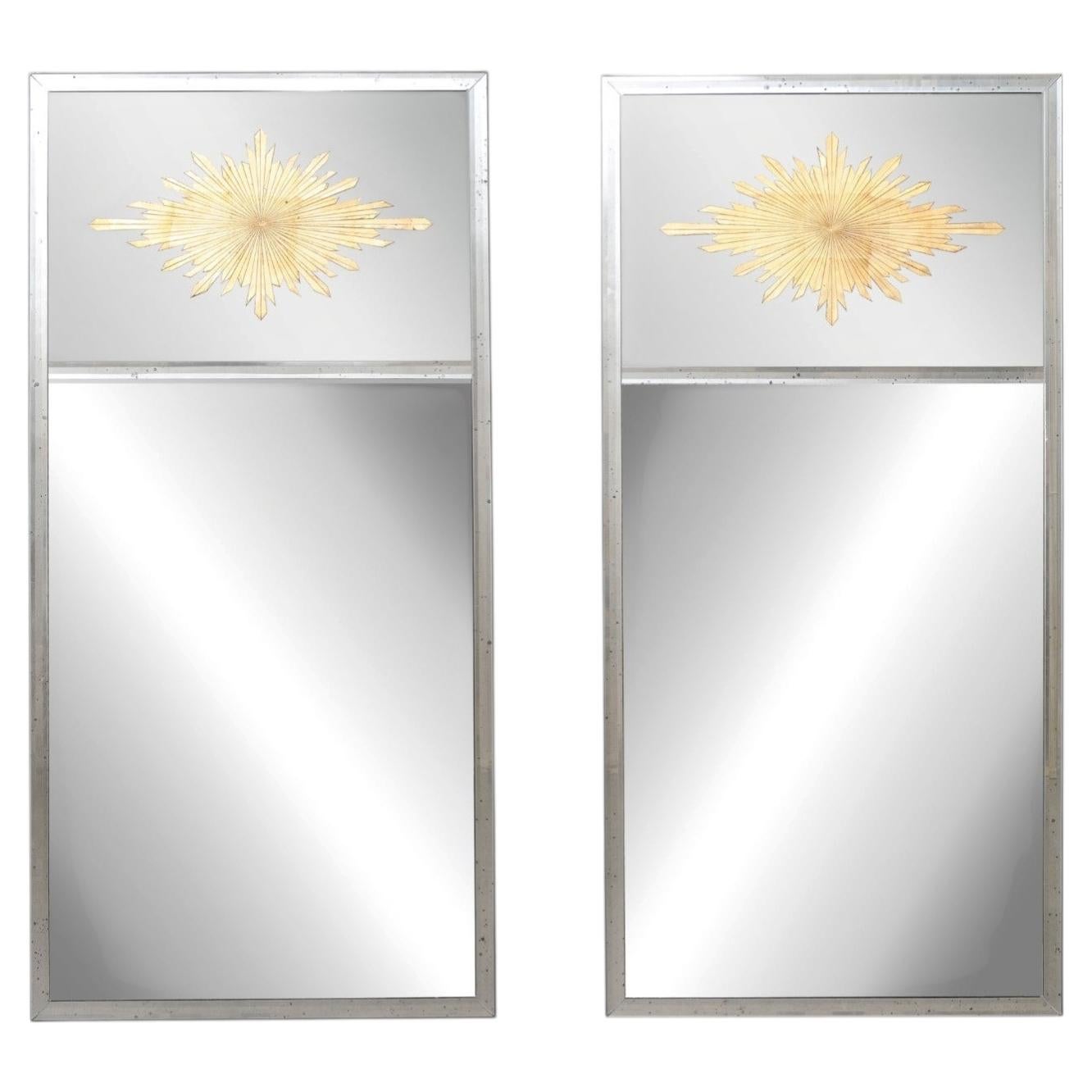 Superbe paire de miroirs artisanaux en argent et or, décorés selon la technique de l'églomisé et représentant un motif en rayons de soleil