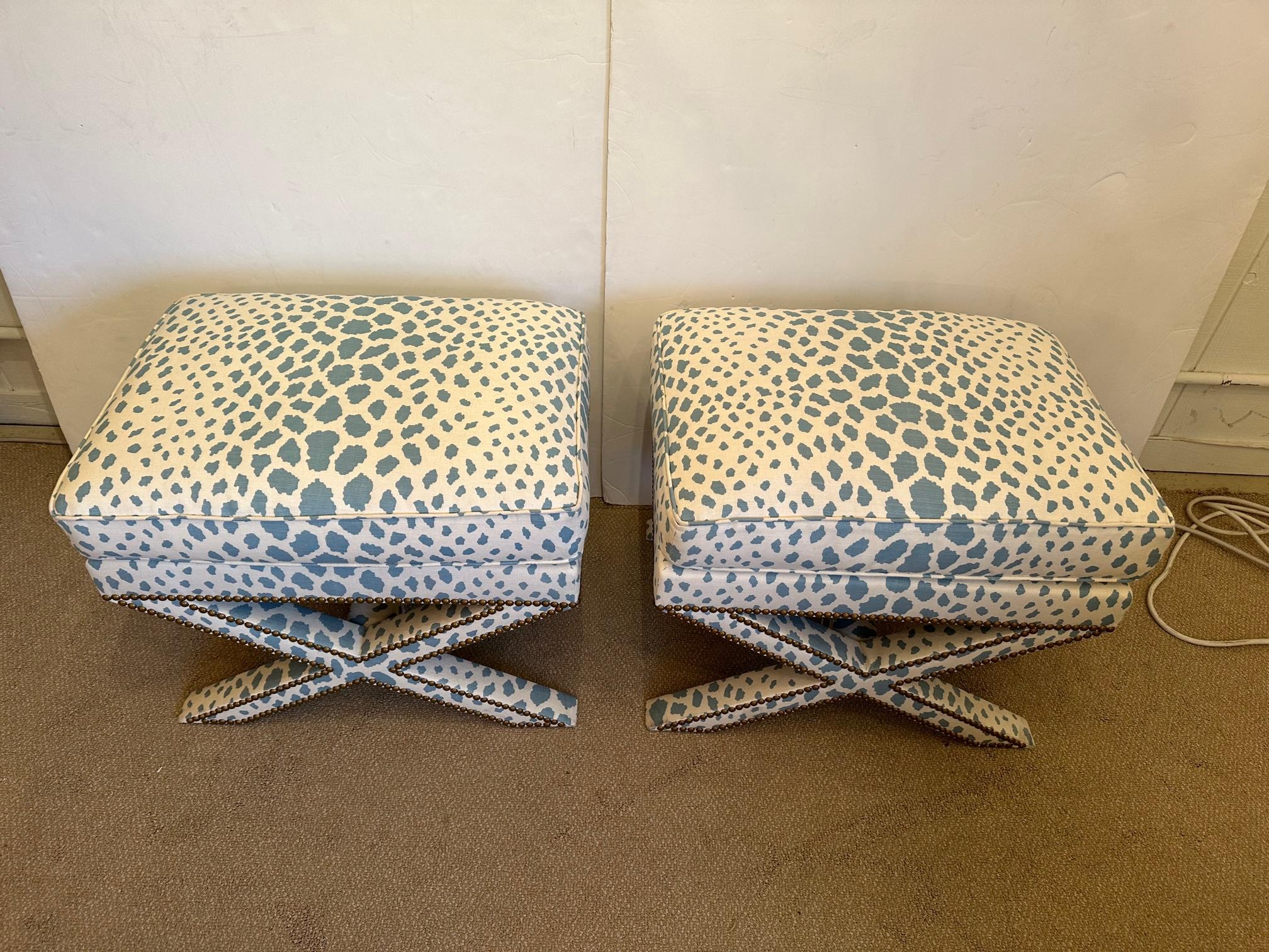 Super stylish iconic Billy Baldwin upholstered benches having classic X shaped stretchers. Newly updated with smashing Quadrille grey blue and white faux leopard fabric with brass nailheads.