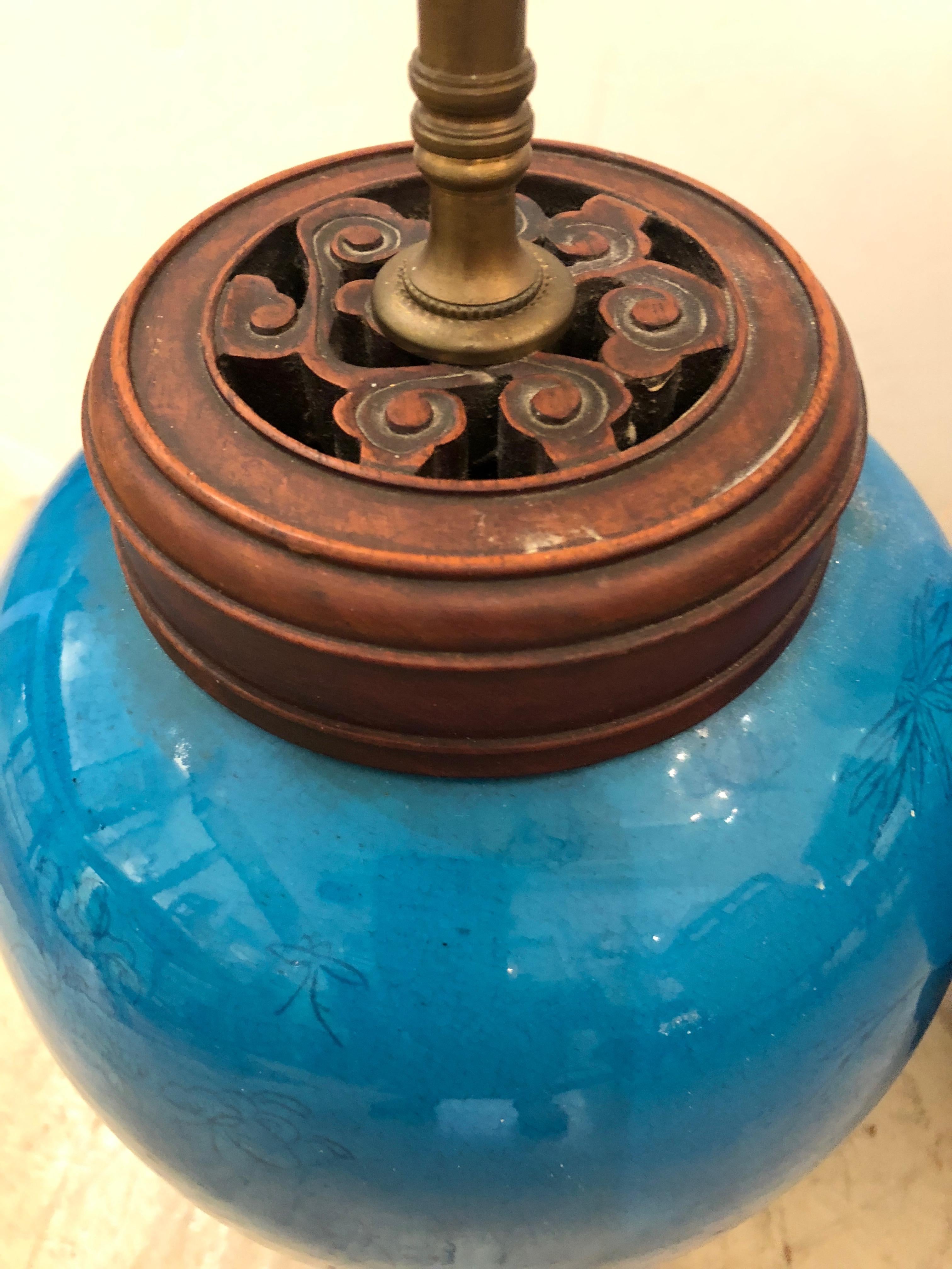 Two antique ginger jar shaped ceramic table lamps having subtle decoration of butterflies and a fabulous turquoise glaze. Hardwood circular tops and stunning stands with several lovely cabriole shaped feet. The jars are 13.5 inches high.