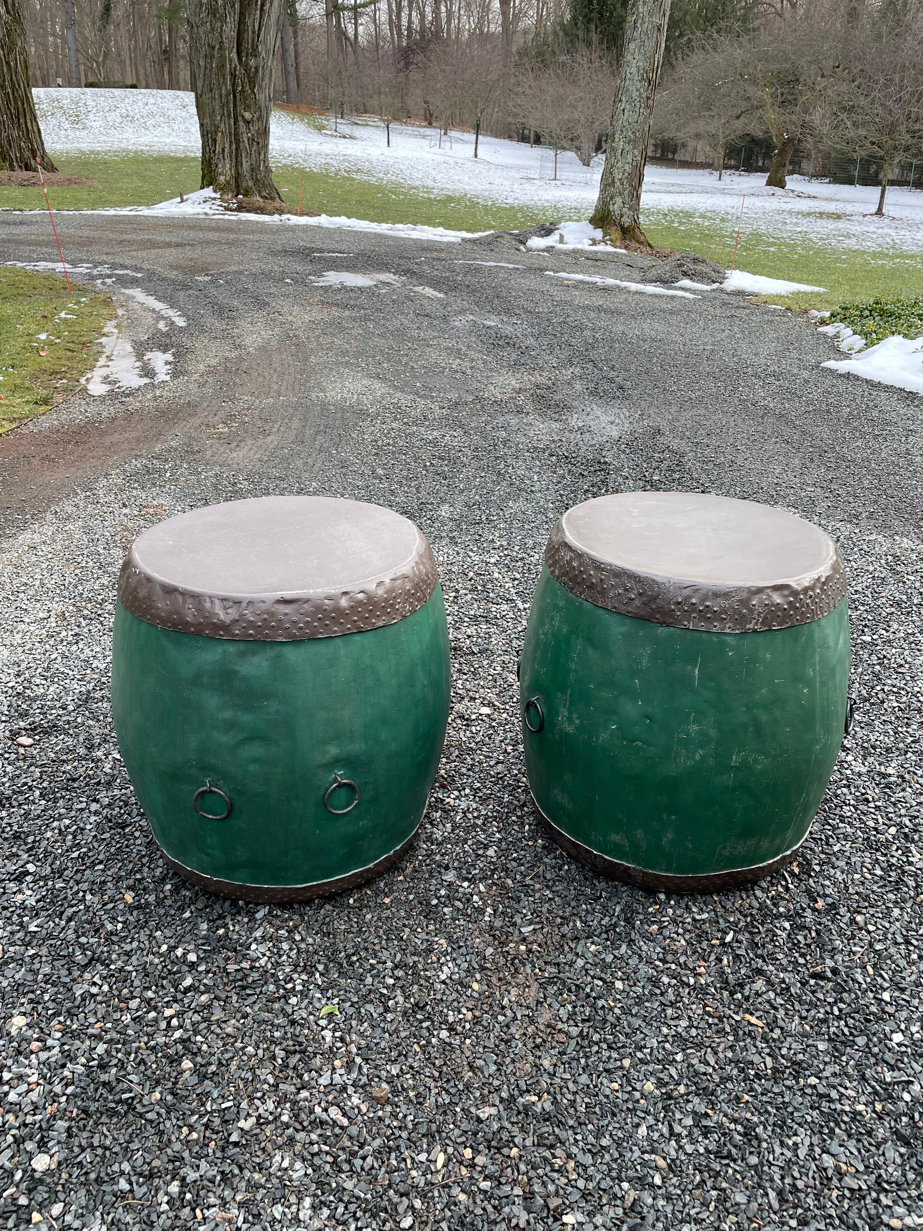 Large pair of beautiful Chinese style drum tables. Each drum is constructed of wood with a metal top and base and are mounted with pairs of metal rings on each side. Unique and a beautiful shade of green! From a Sea Island, Georgia estate.