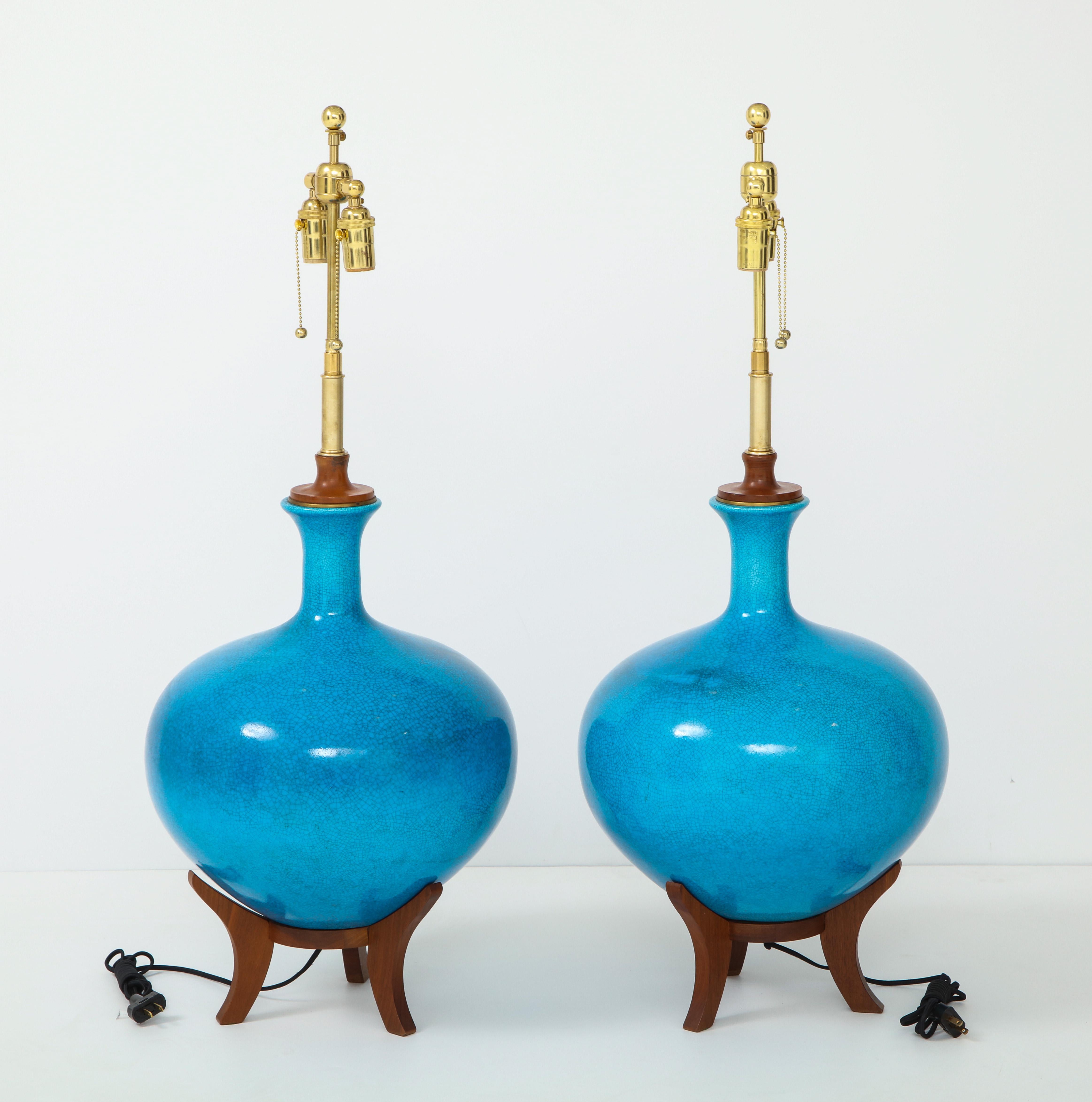 Fabulous pair of midcentury lamps by Frederick Cooper.
The lamps have a stunning cerulean blue crackle glazed finish and they
sit on wooden bases.
They have been newly rewired with polished brass double clusters.
 