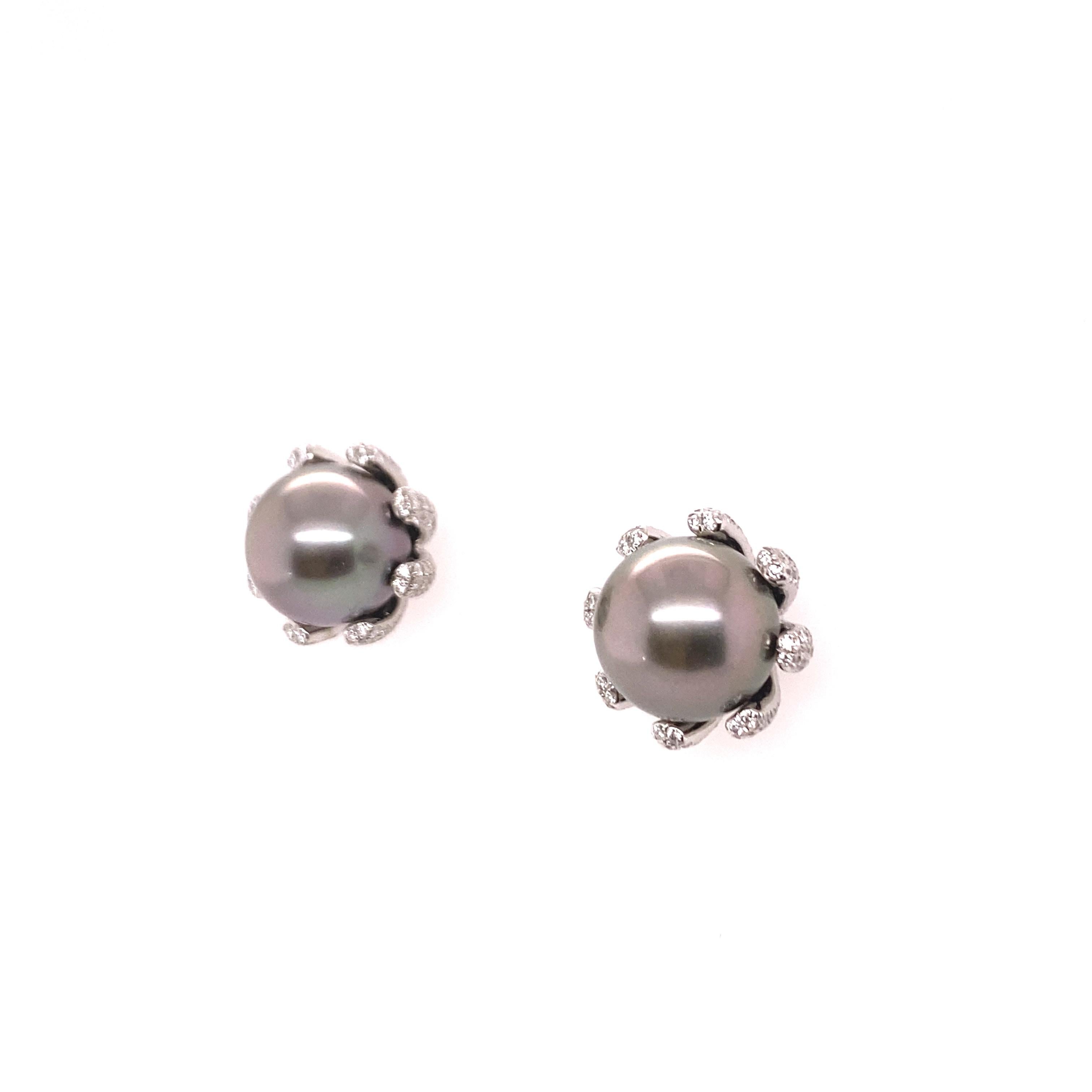 Magnifique paire de clous d'oreille fabriqués en or blanc 18 carats, centrés chacun sur une perle de culture de Tahiti de 10,0 et 10,5 mm de diamètre. Les perles sont de formes parfaitement rondes, d'une couleur gris foncé moyen, avec de légers
