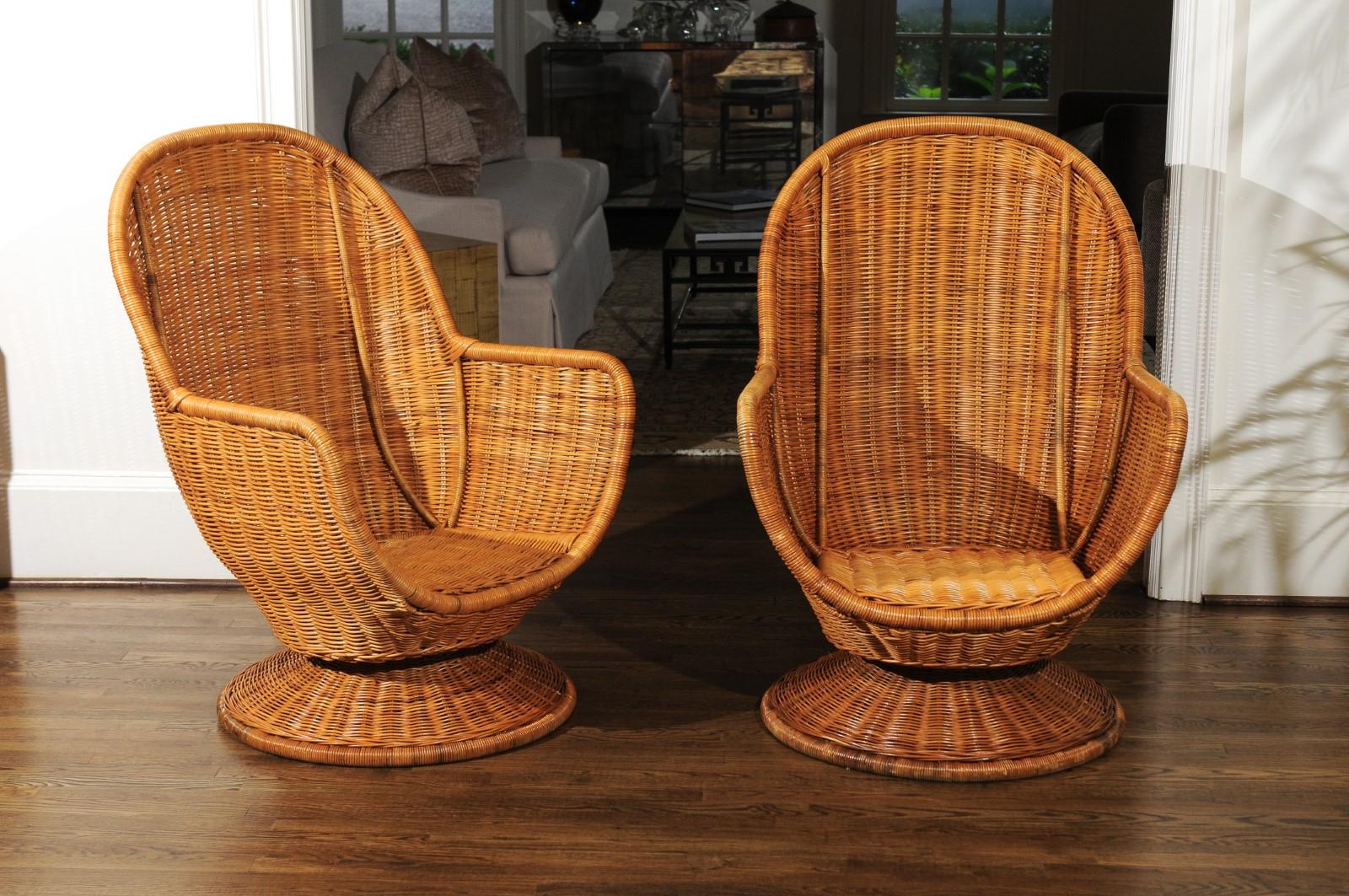 A stellar restored pair of egg style wicker swivel club or lounge chairs, circa 1975. Heavy steel frame and base veneered in woven wicker. Exceptional design, material quality and craftsmanship. The wicker has aged to absolute perfection. Important