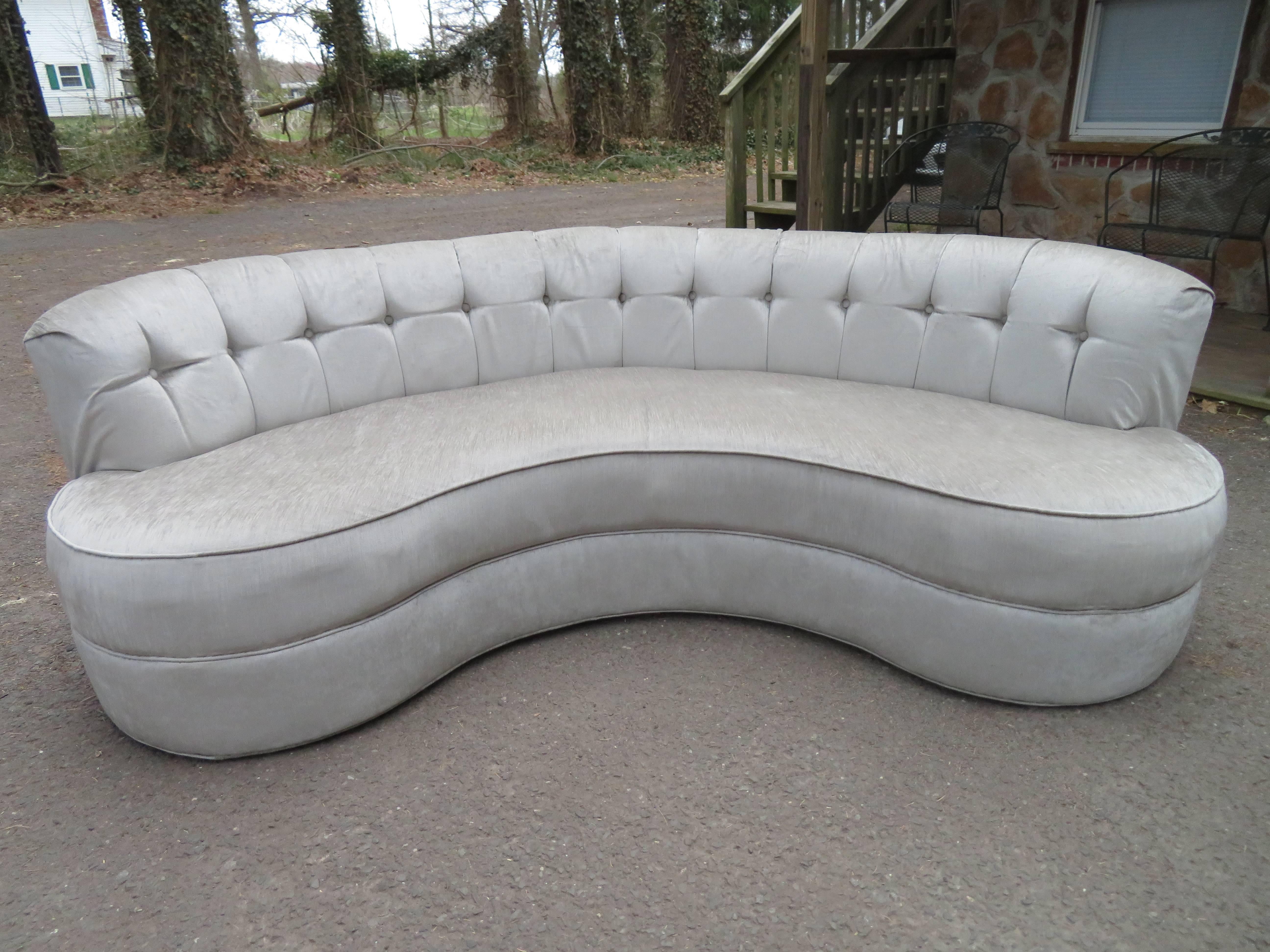 Fabulous Pair of tufted back curved kidney shaped sofas. This pair was re-upholstered about 5 years ago with a gorgeous taupe grey velvet which still looks great.