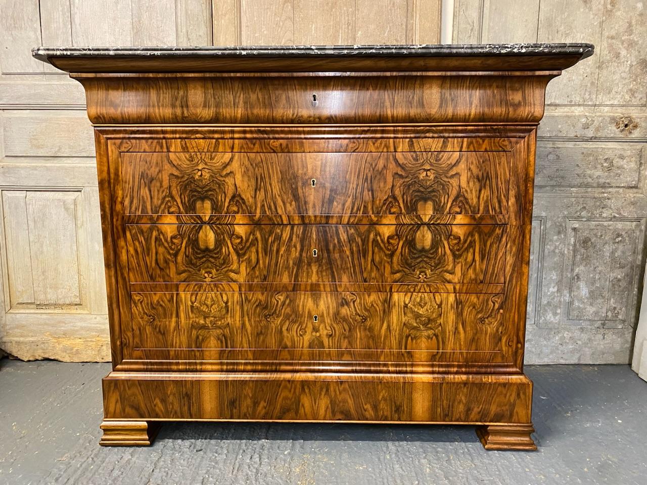 A stunning French marble top commode chest of drawers, made from walnut and excellent tight burr walnut to the front. The grey veined marble top is in excellent condition. The drawers all run smoothly and it has the rare extra secret drawer in the