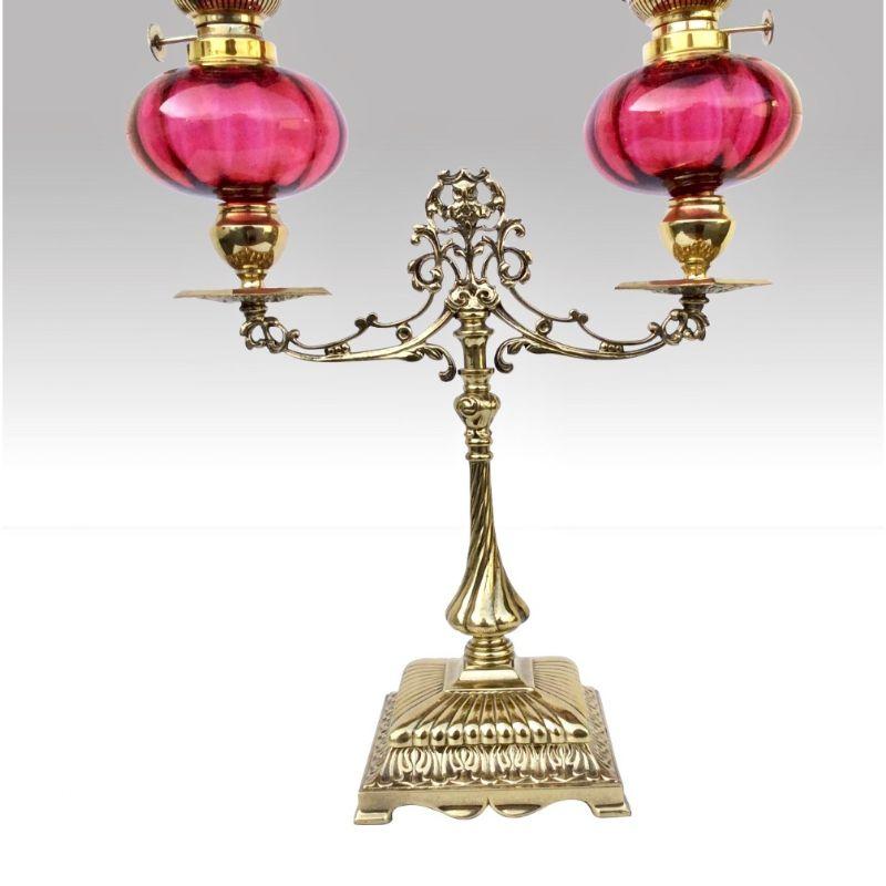 Fabulous rare antique double peg oil lamp with red ruby glass fonts and jack in the Pulpit style frilled shades on brass double column

Circa 1890 
23 ins x 12 ins x 5 ins 
 
Declaration: This item is antique. The date of manufacture has been