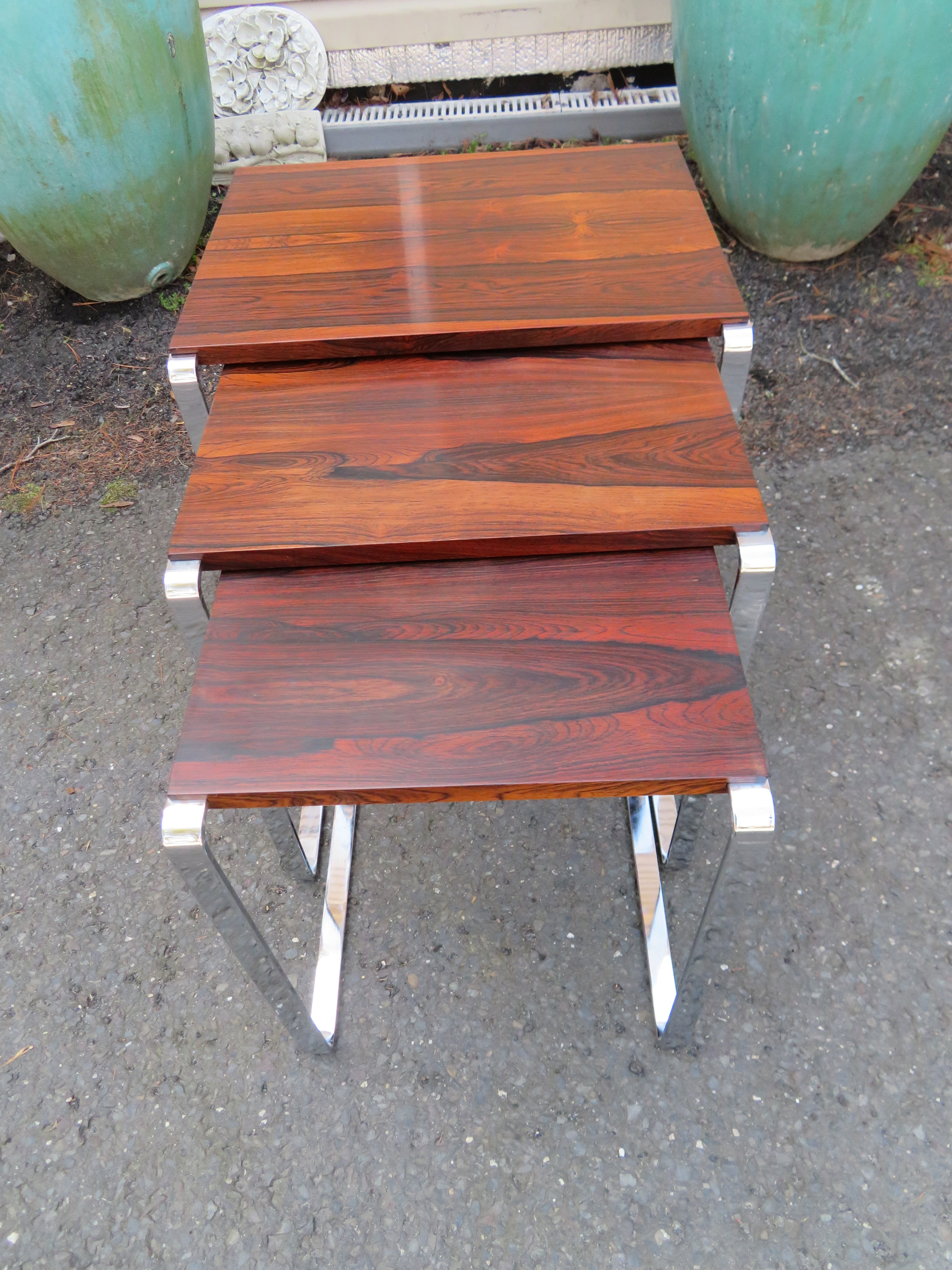 Fantastic set of 3 rosewood nesting tables designed by Richard Young for Merrow. These Fine tables are in very nice vintage condition with only light signs of age. They retain a rich dark rosewood color and the chrome has a mirror shine. The largest