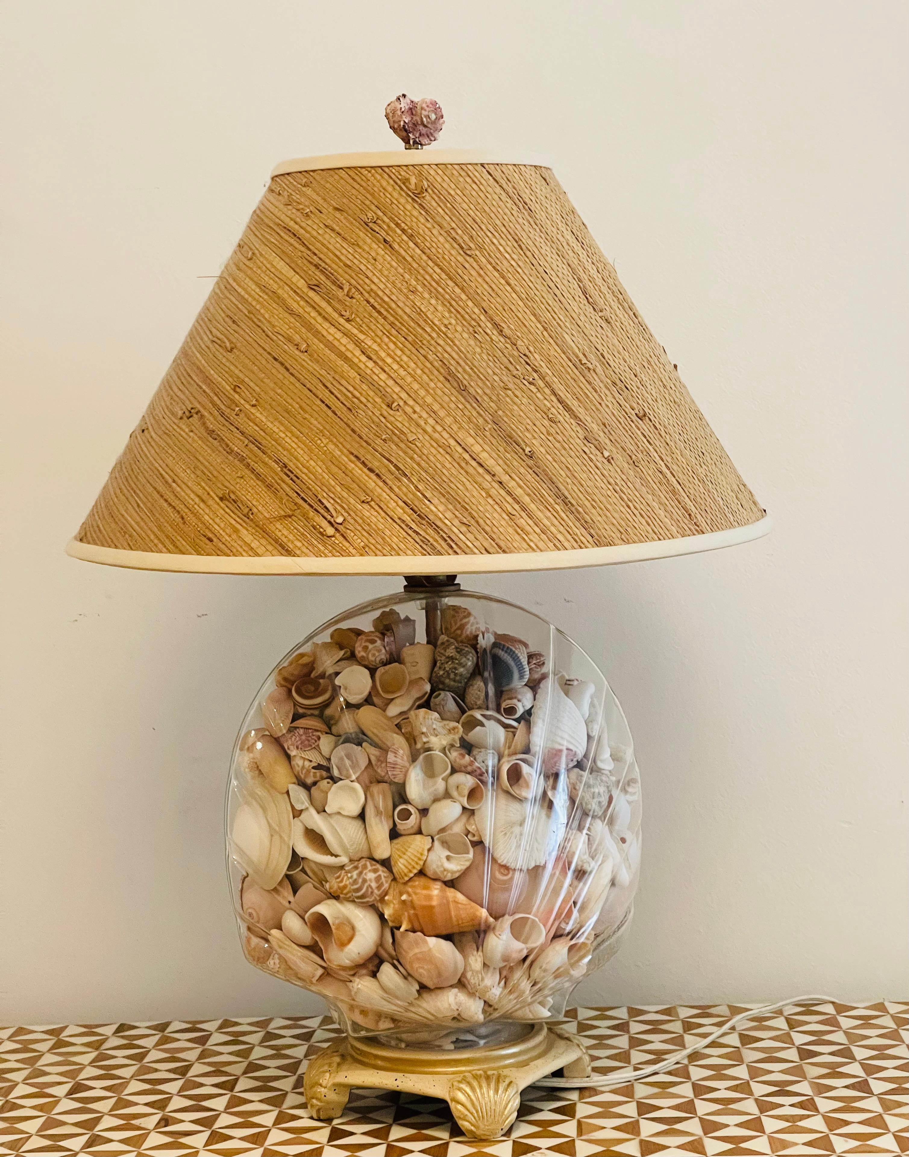 Fabulosa lámpara vintage de conchas marinas en jarrón de cristal tallado , rellena de conchas marinas de Florida, en. Base de metal y pantalla de tela de hierba.