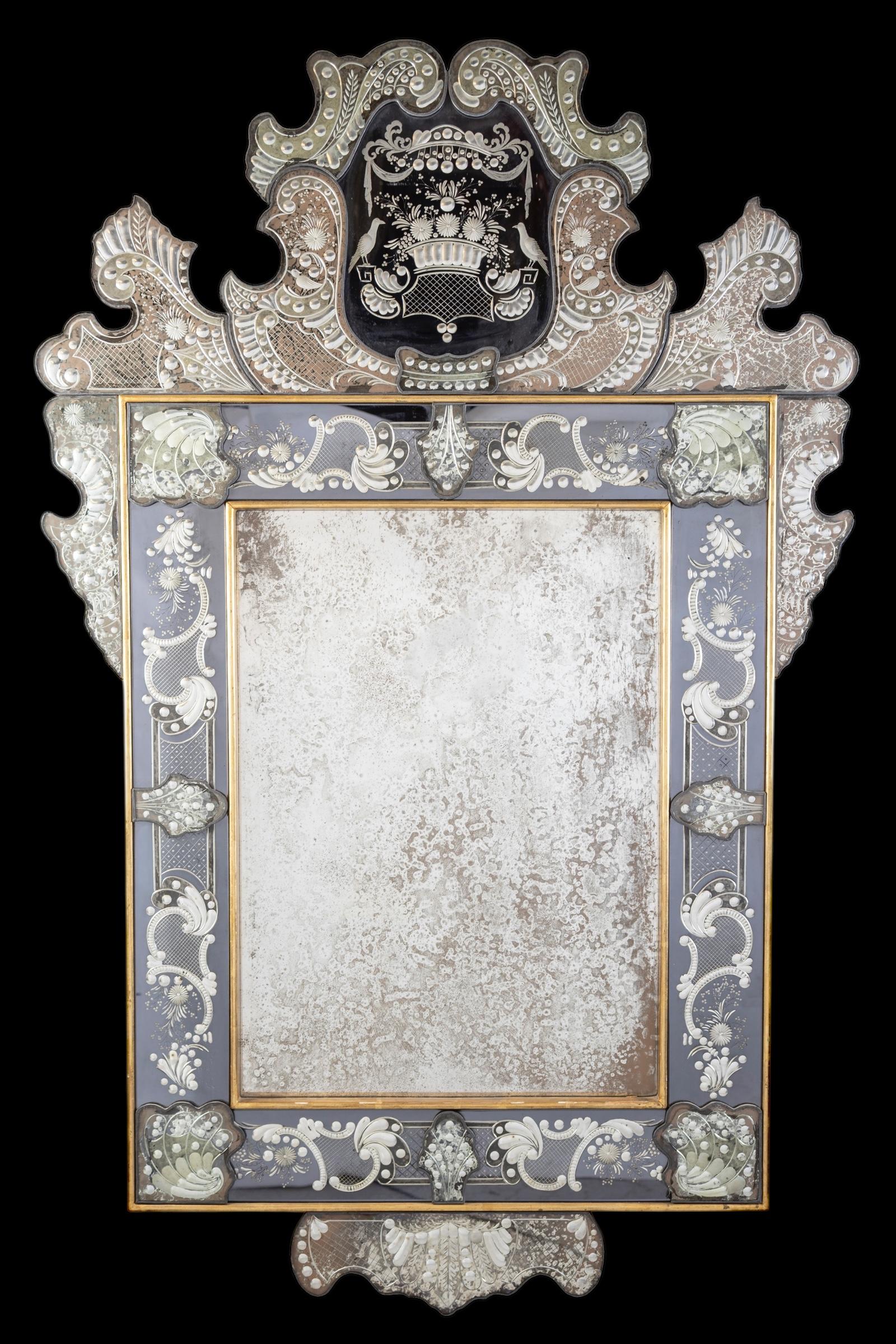 This beautiful and large Venetian mirror with finely etched  liberty motifs adorning the mirrored frame, the crest centered with a dark glass .
 Executed by the great Master of Murano.
 Very good original condition with a ware of time. 
We will