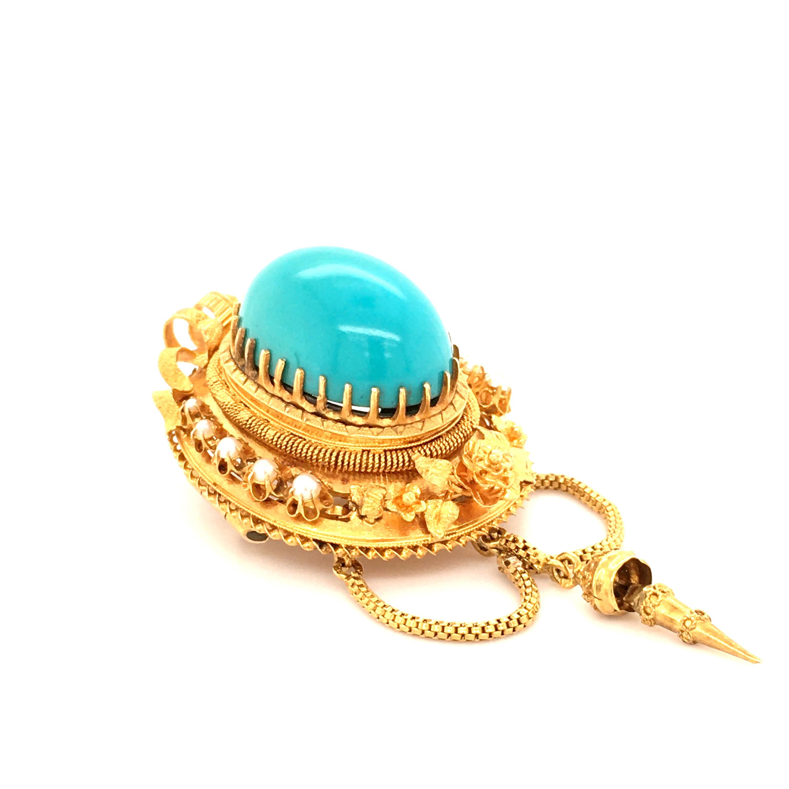 A superb brooch with a brightly colored turquoise Cabochon measuring 20 x 14mm, accented by ten natural pearls.
