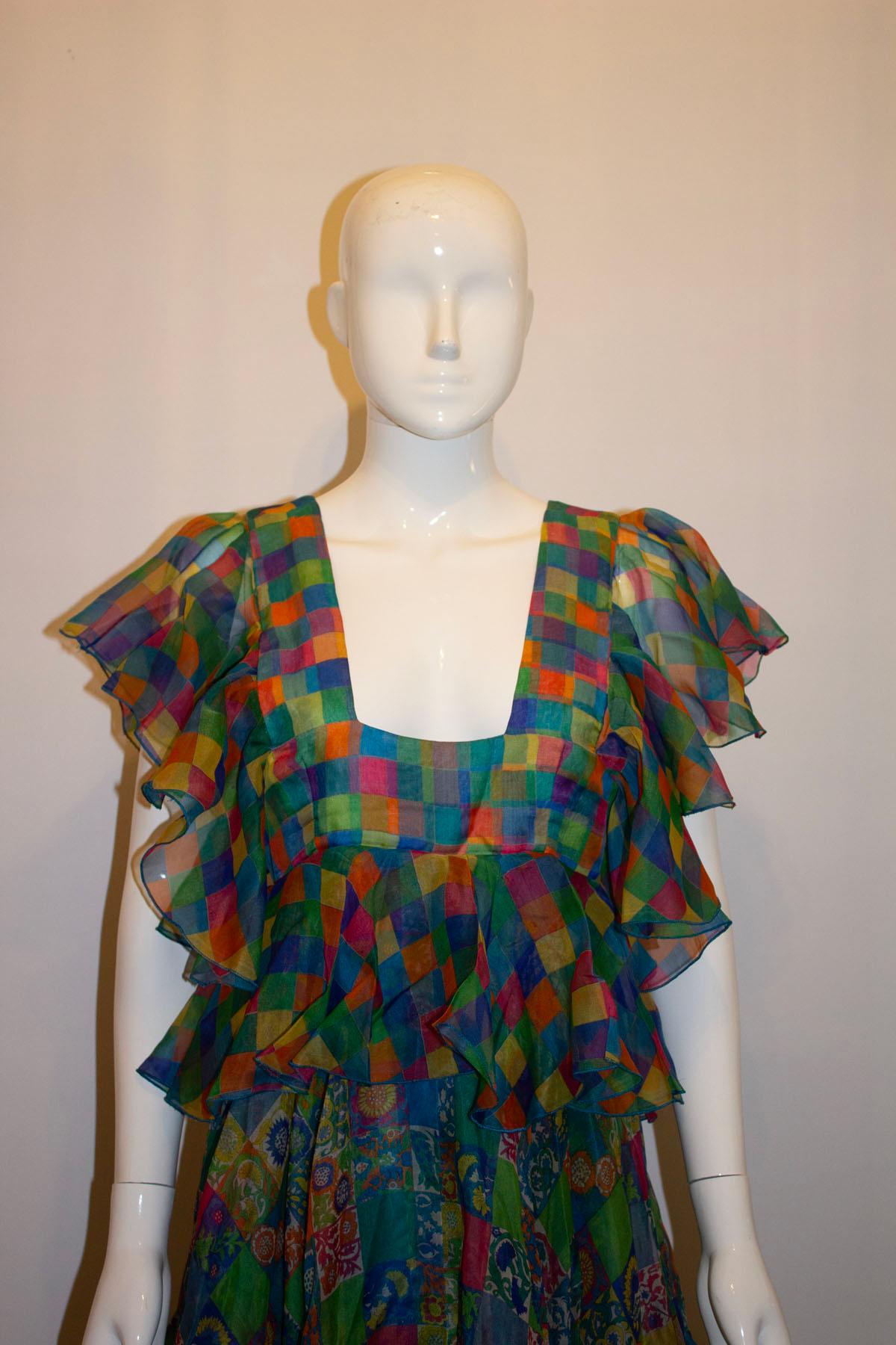 A stunning superb silk print mix vintage gown by Gina Fratini.  In a wonderful clash of colour and print, the dress has frill sleaves, a square neckline at the front and attractive v backline at the back.  It is fully lined, and has a back central