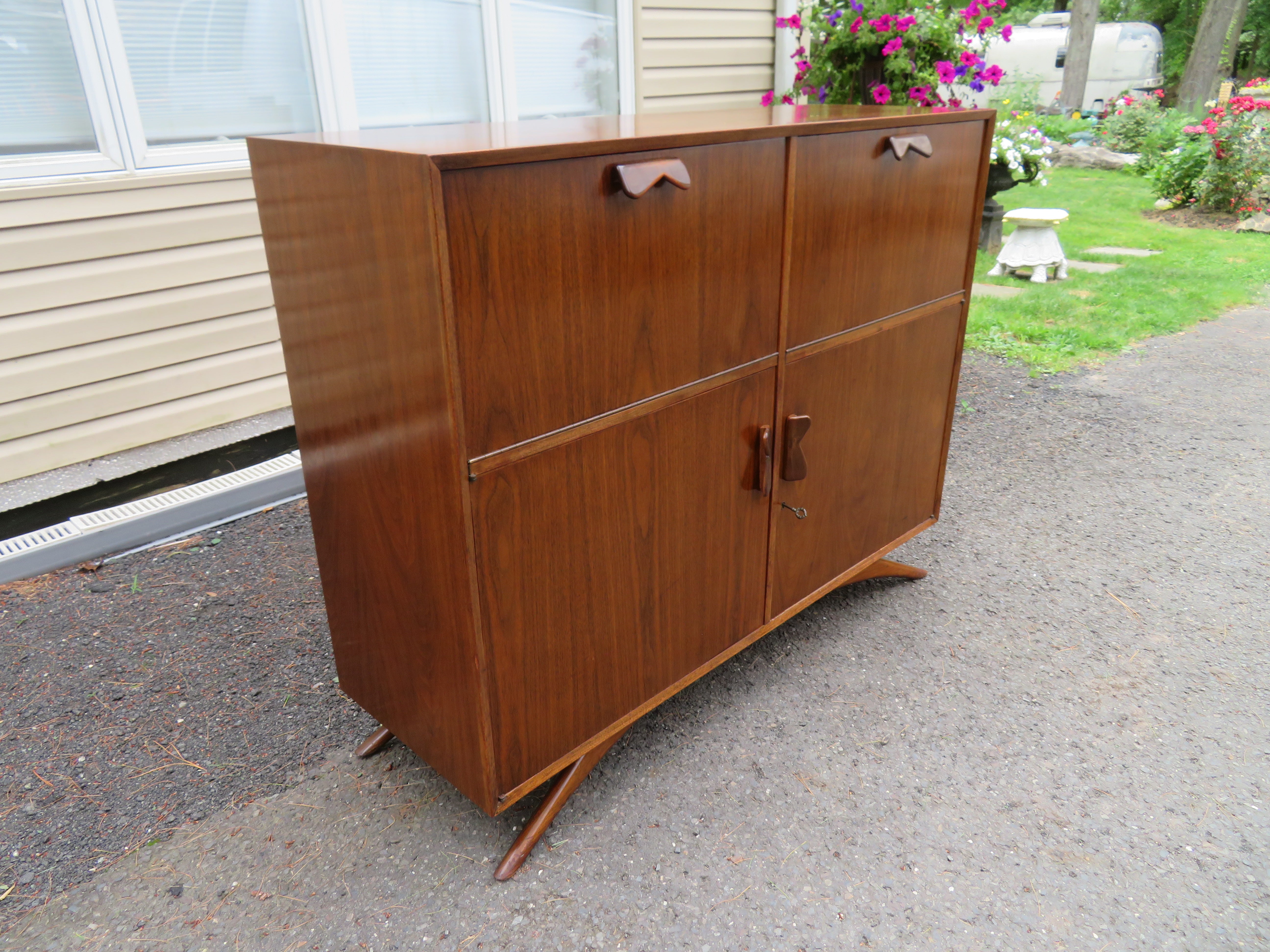 Fabulous Grosfeld House style walnut splayed legs bar cabinet. We love everything about this wonderful cabinet with the 2 pull-down doors revealing cubbies on one side and open space on the other. The bottom doors swing open to reveal a large open