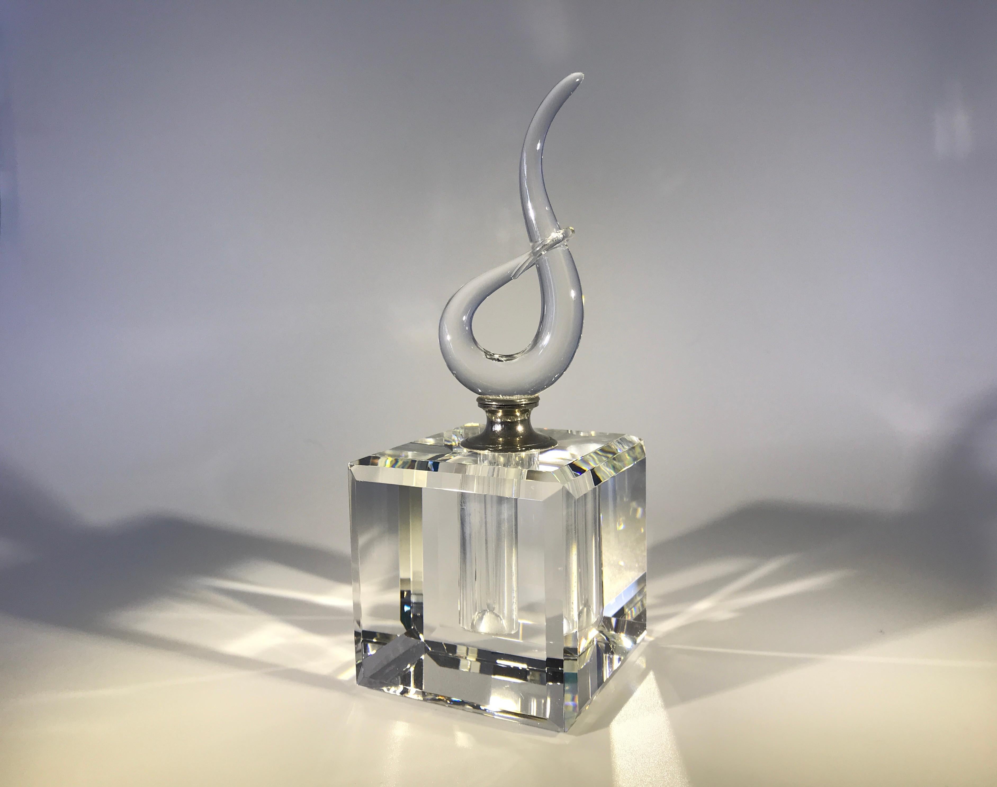 A fabulously entwined clear French crystal, faceted cube perfume bottle from the 1970s
A weighty and impressive piece with a delicate entwined crystal stopper
Silver colored collar. The glass pipet scent rod is in perfect condition
circa