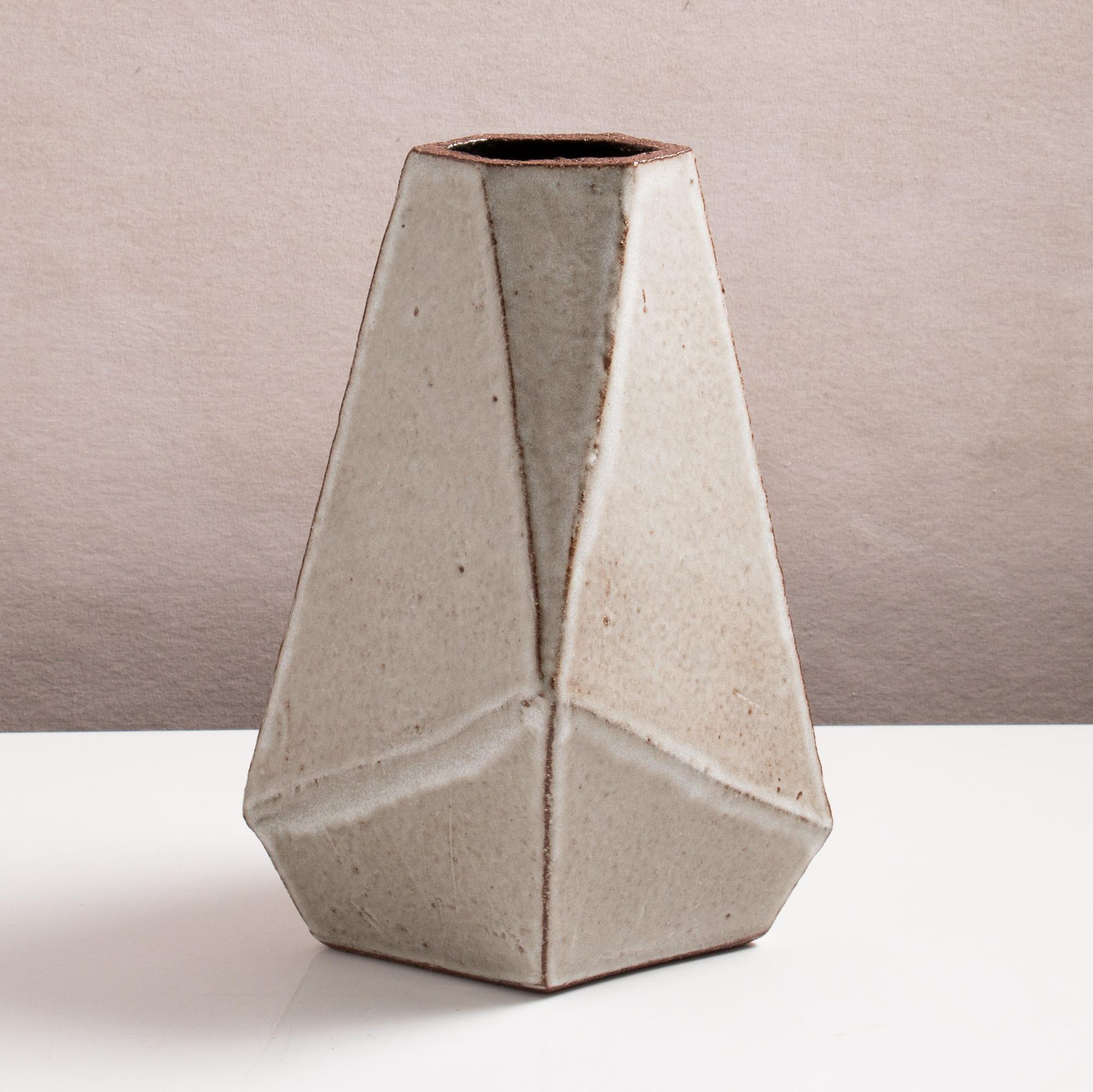 Inspired by midcentury Brutalist architecture, this tapered ceramic vase combines clean geometric lines with the warmth and individuality inherent in handmade work. The complex geometric shape narrows to slender opening for flowers or small