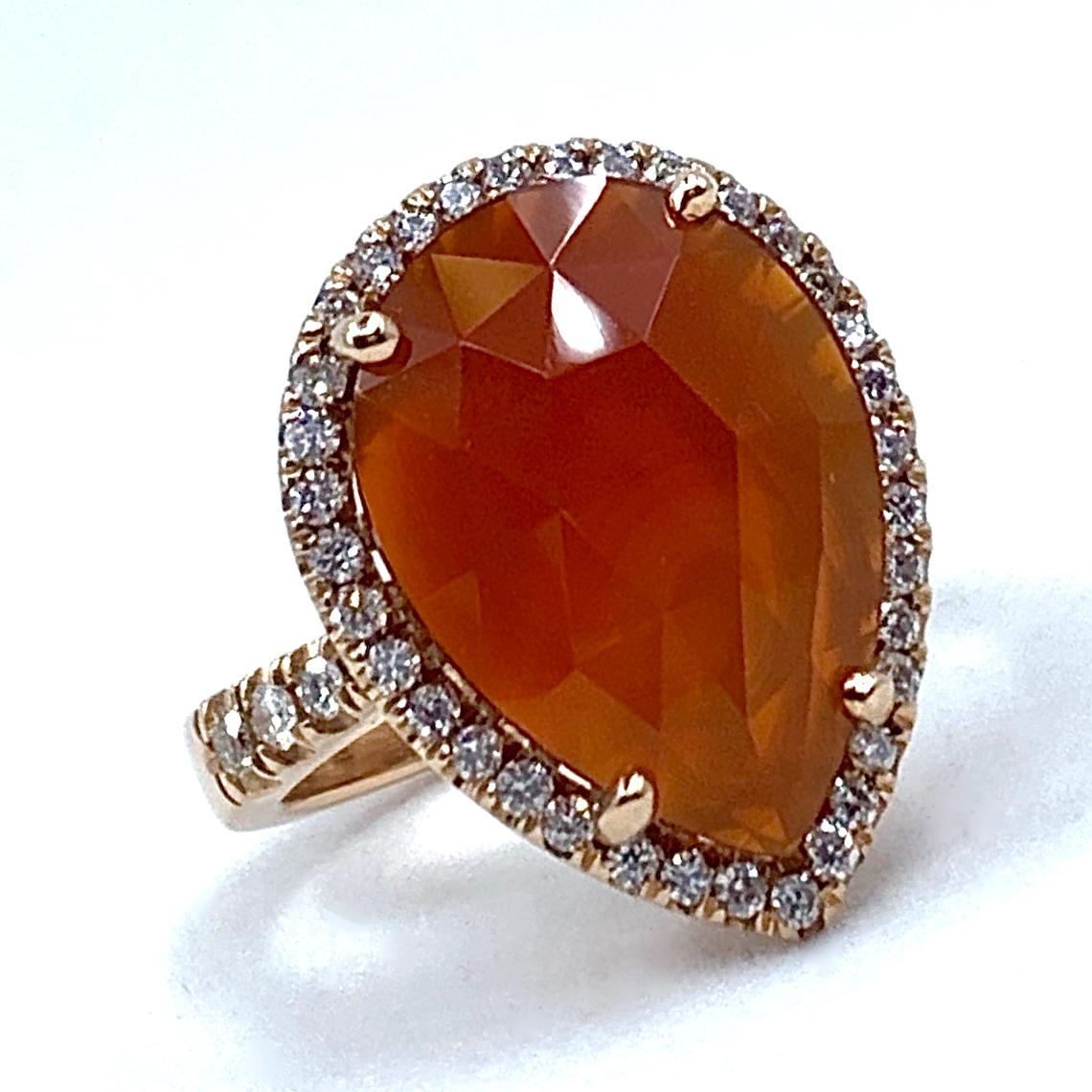 This one-of-a-kind ring was designed, set and finished here in our shop by Eytan Brandes.

A large, slightly translucent pear-shaped slice of faceted carnelian is prong-set in a high basket and surrounded by 34 pavé-set diamonds.  

Four