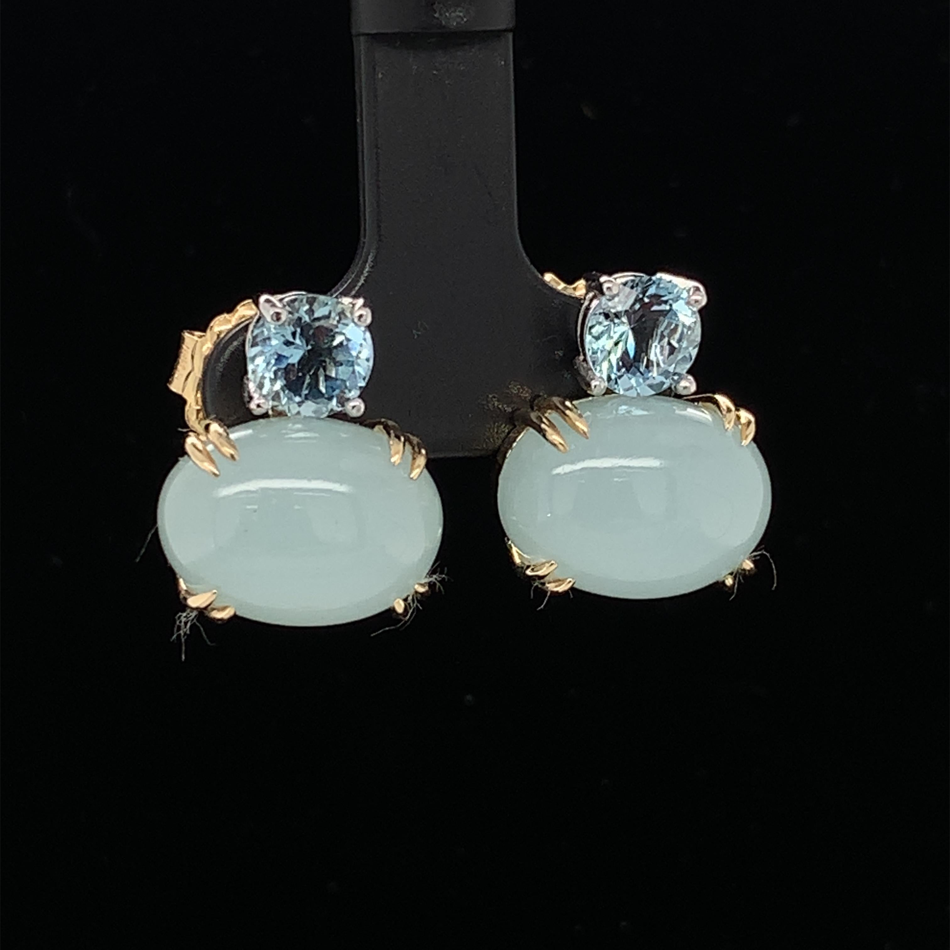 These lovely 18k two-toned gold earrings feature aquamarine in both faceted rounds and oval cabochons. The round faceted aquamarine are a beautifully crystalline, brilliant shade of sparkling medium blue, while the oval cabochons are a gorgeously
