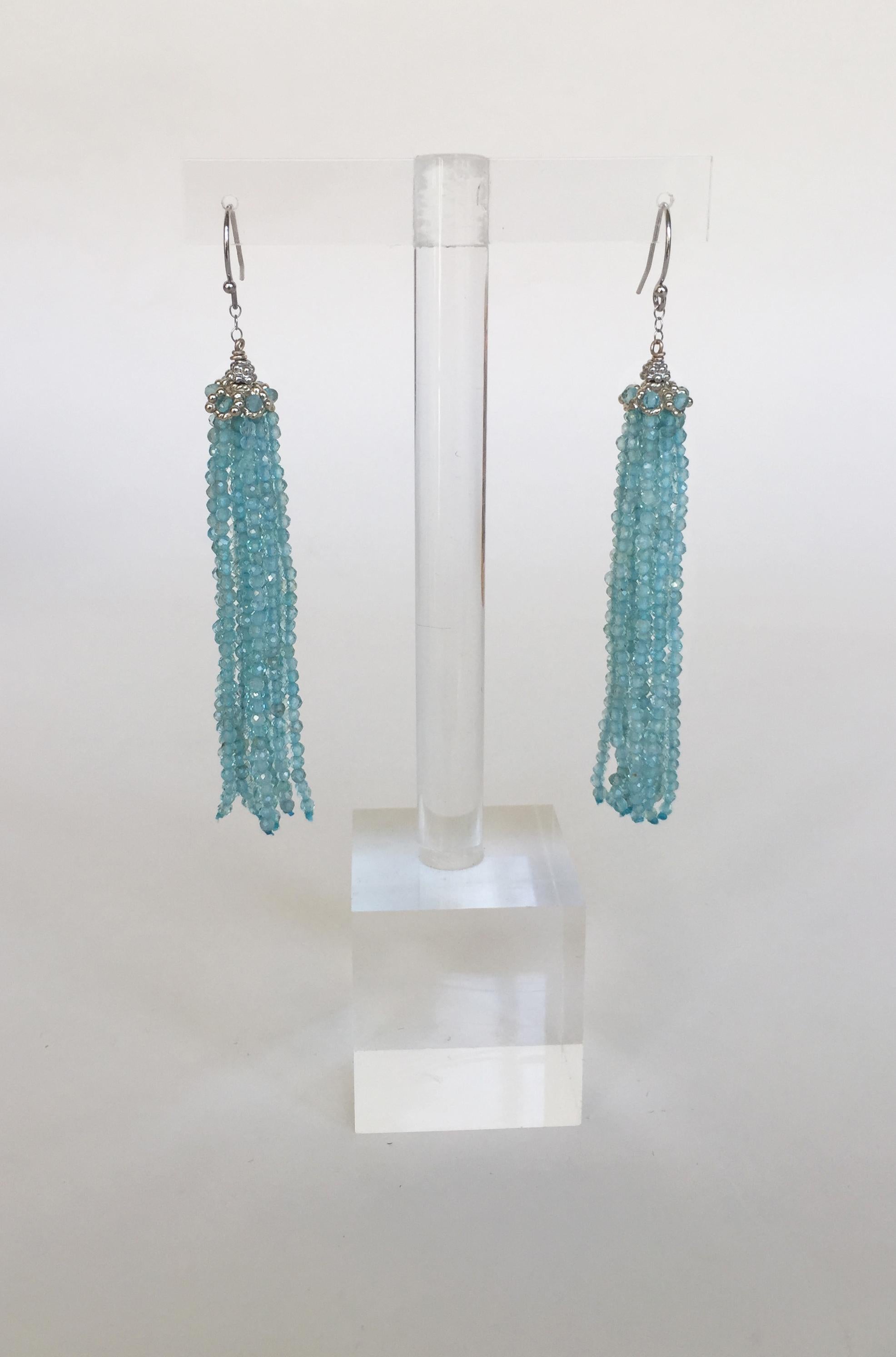 These faceted aquamarine tassel earrings with 14k white gold roundel, chian, and hook are iridescent with shimmering strands of aquamarine beads. At 3.1 inches these beautiful earrings accent the face well. The icey blue of the aquamarine is