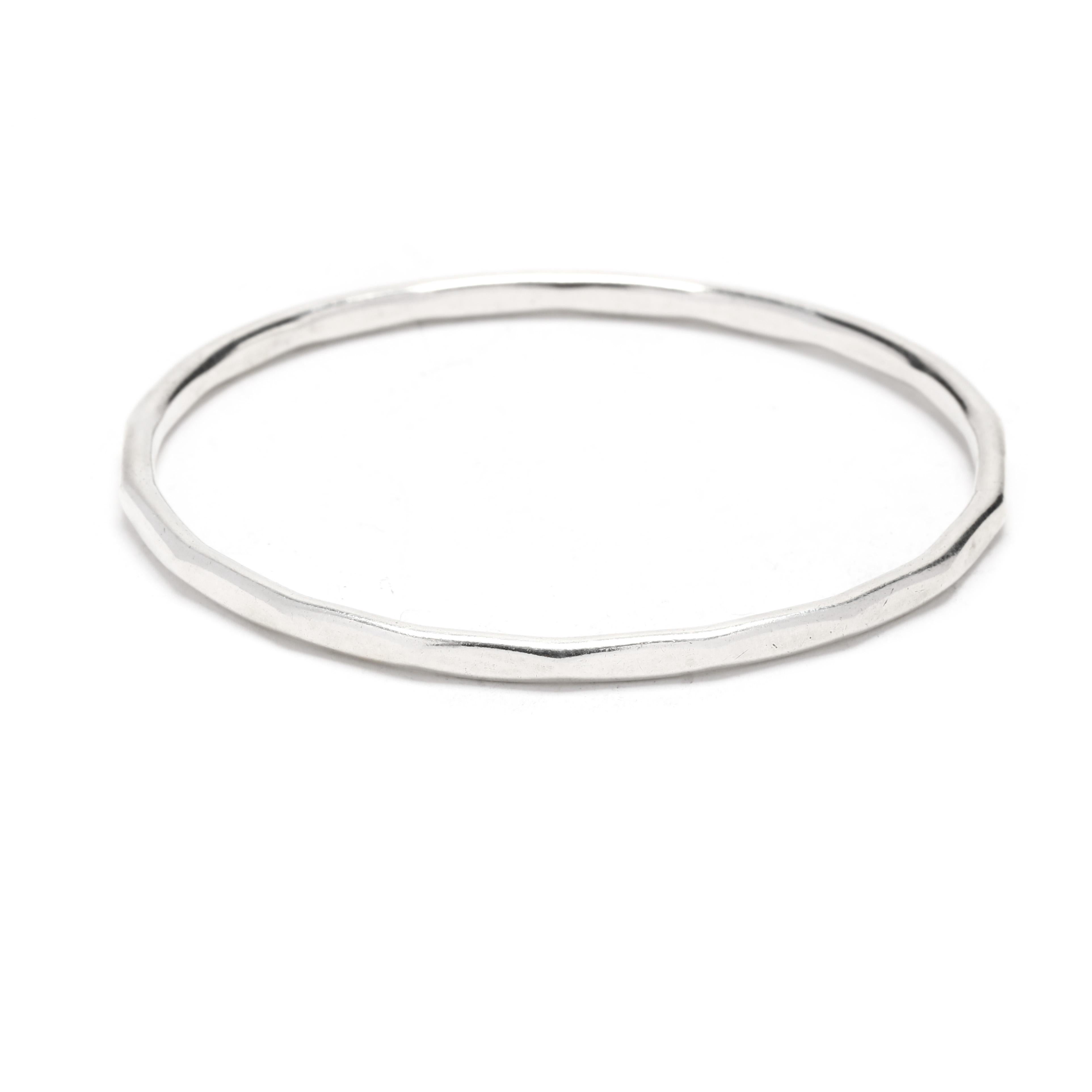 A vintage sterling silver bangle bracelet, This stackable bracelet features a rounded interior, the exterior with flattened sections to create a geometric design.  It tests sterling silver. 

Length: 7.75 inch interior circumference

Width: 3.7
