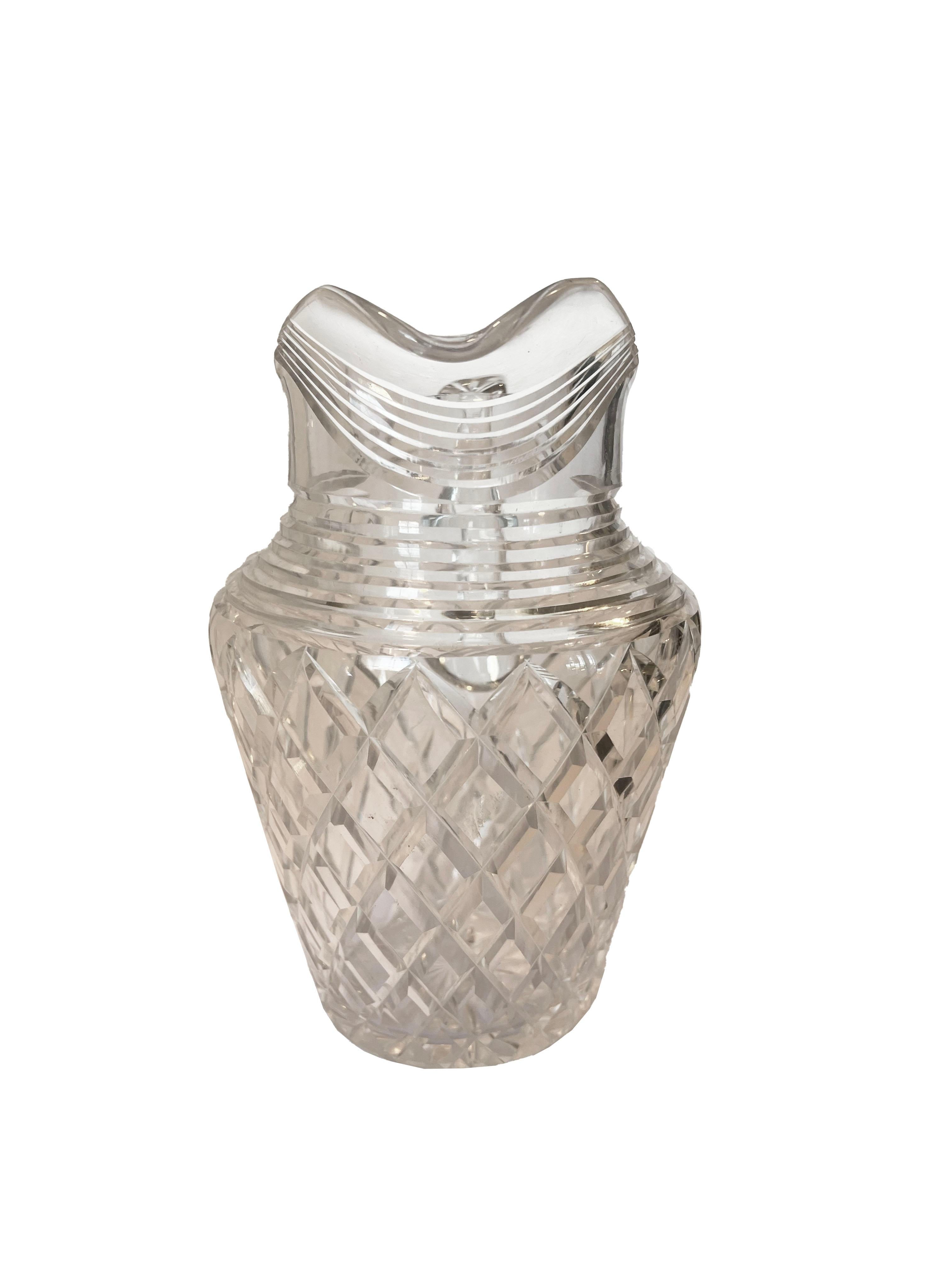 A dazzling crystal faceted pitcher, an exquisite addition to elevate your table setting with a touch of glamour. Though unsigned, this pitcher exudes a timeless elegance, showcasing its craftsmanship through brilliant facets that catch and reflect