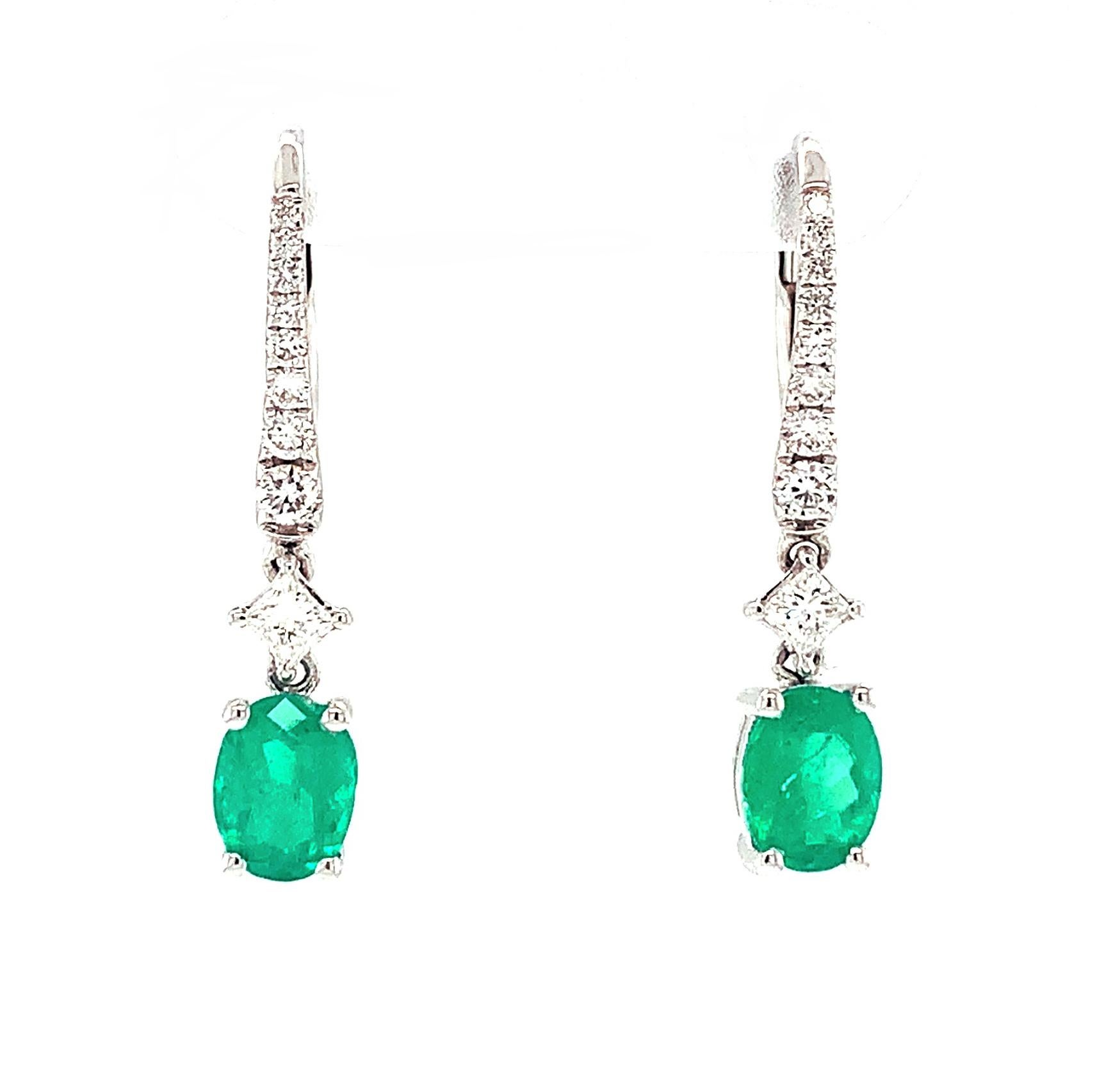 Bright green emeralds are featured in these pretty drop earrings set in 18k white gold. The gorgeous, matching emeralds have a combined weight of 1.15 carats and are combined with graduating round brilliant-cut diamonds set in elegant lines leading