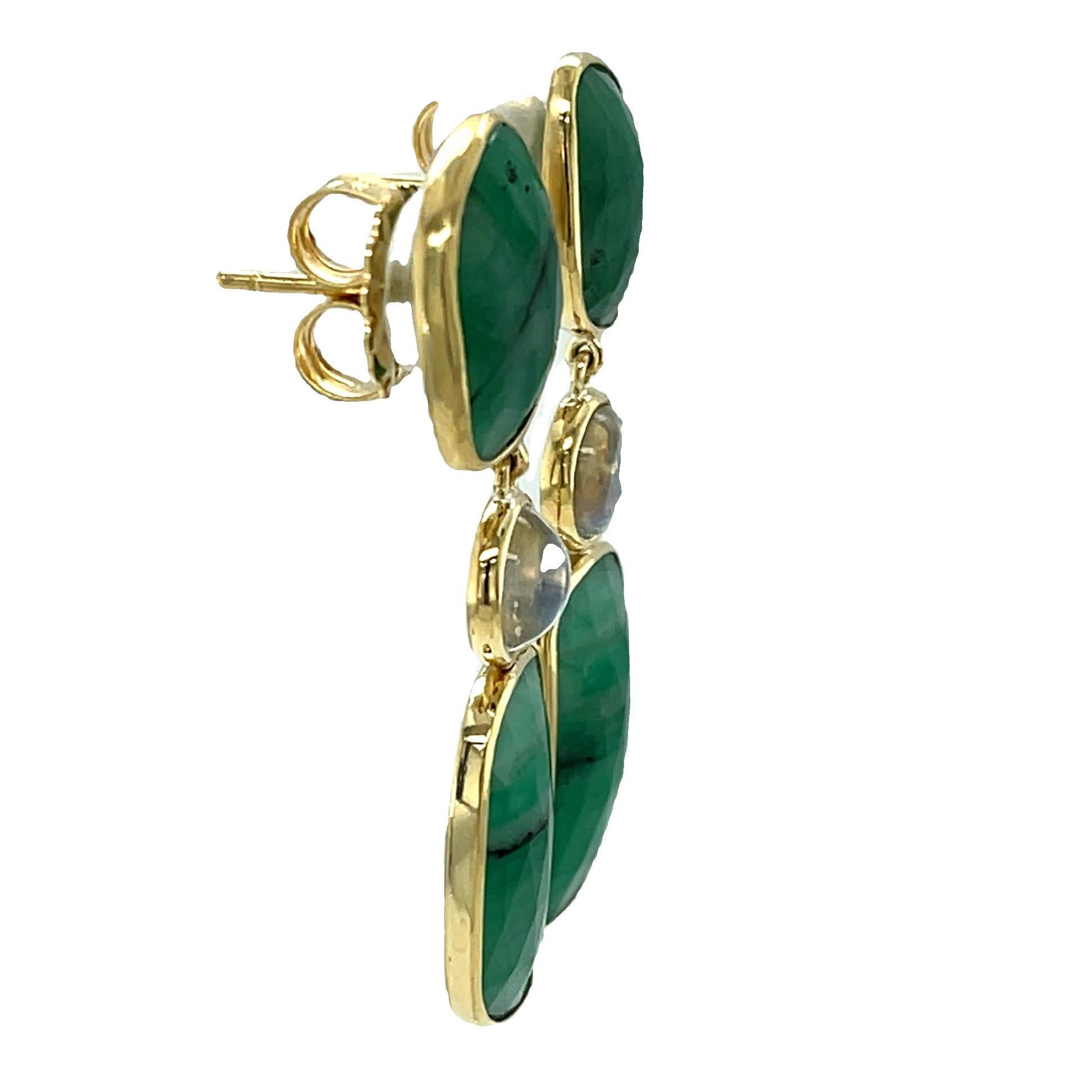 These beautifully dramatic and stylish earrings feature faceted emerald slices paired with rainbow moonstones set in 18k yellow gold! The emeralds are free-form in shape with luscious green body color variegated with natural black veining that give