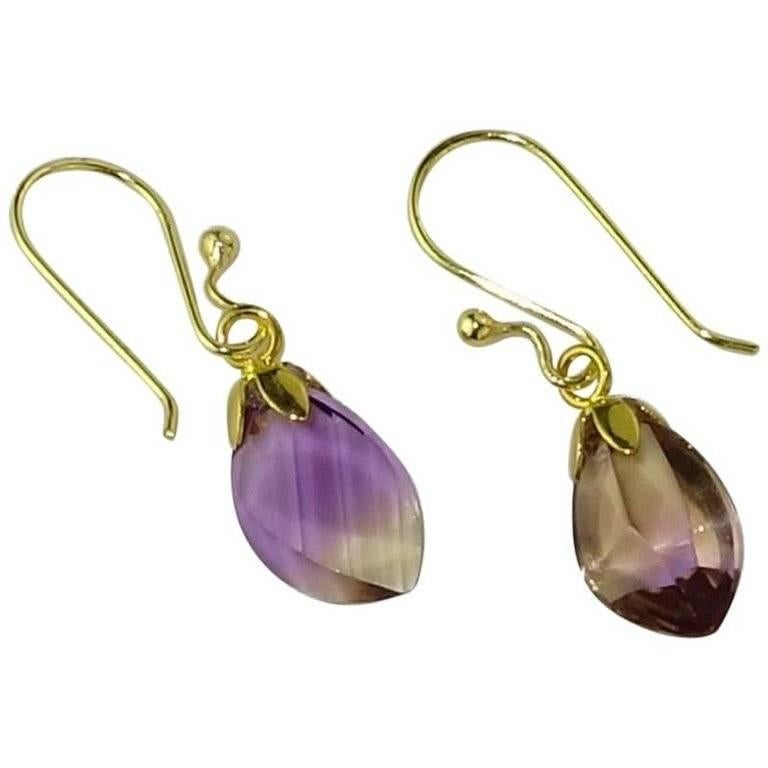 Brazilian Free form Ametrine Earrings on 18kt gold plated hooks. These gemstones are not matching, but are approximately equal in size and weigh a total of 11.80 cts. They sparkle and flash due to the unique faceting on each gemstone. Combine with