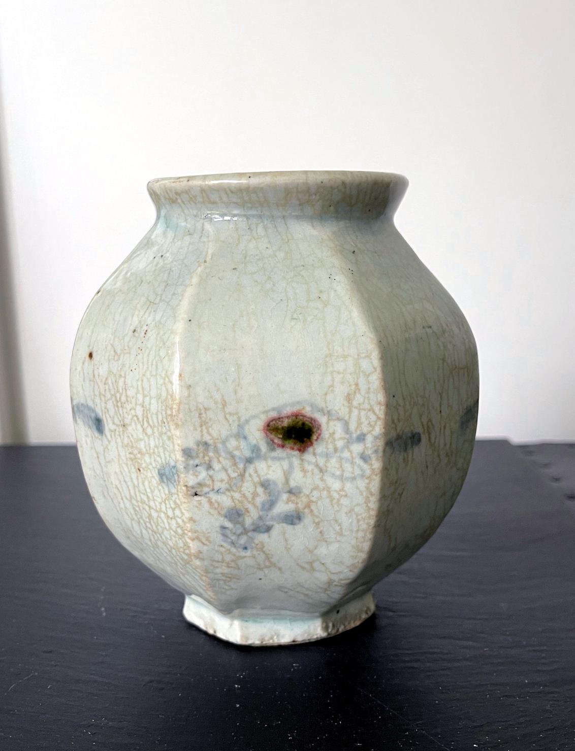 A small ceramic celadon storage jar circa 18th century of Korean Joseon Dynasty. The melon shape jar with a mouth and base of the same size display a beautiful harmony in its form. The body showcases an octagon facet with vigorous lines and angles.