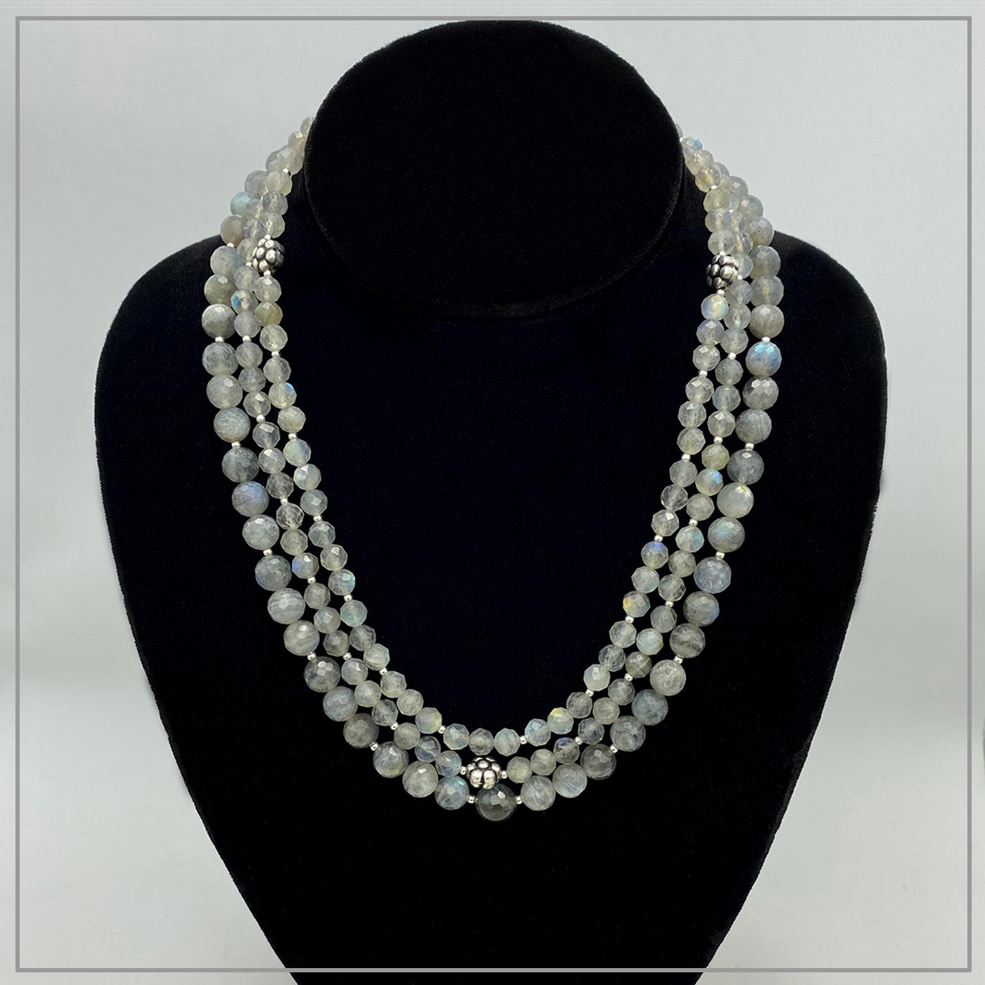 This is a triple strand labradorite necklace with sterling components. We created it with one strand of 8 mm natural gray labradorite beads and two strands of 6mm translucent labradorite. Also this light gray necklace is decorated with three 950
