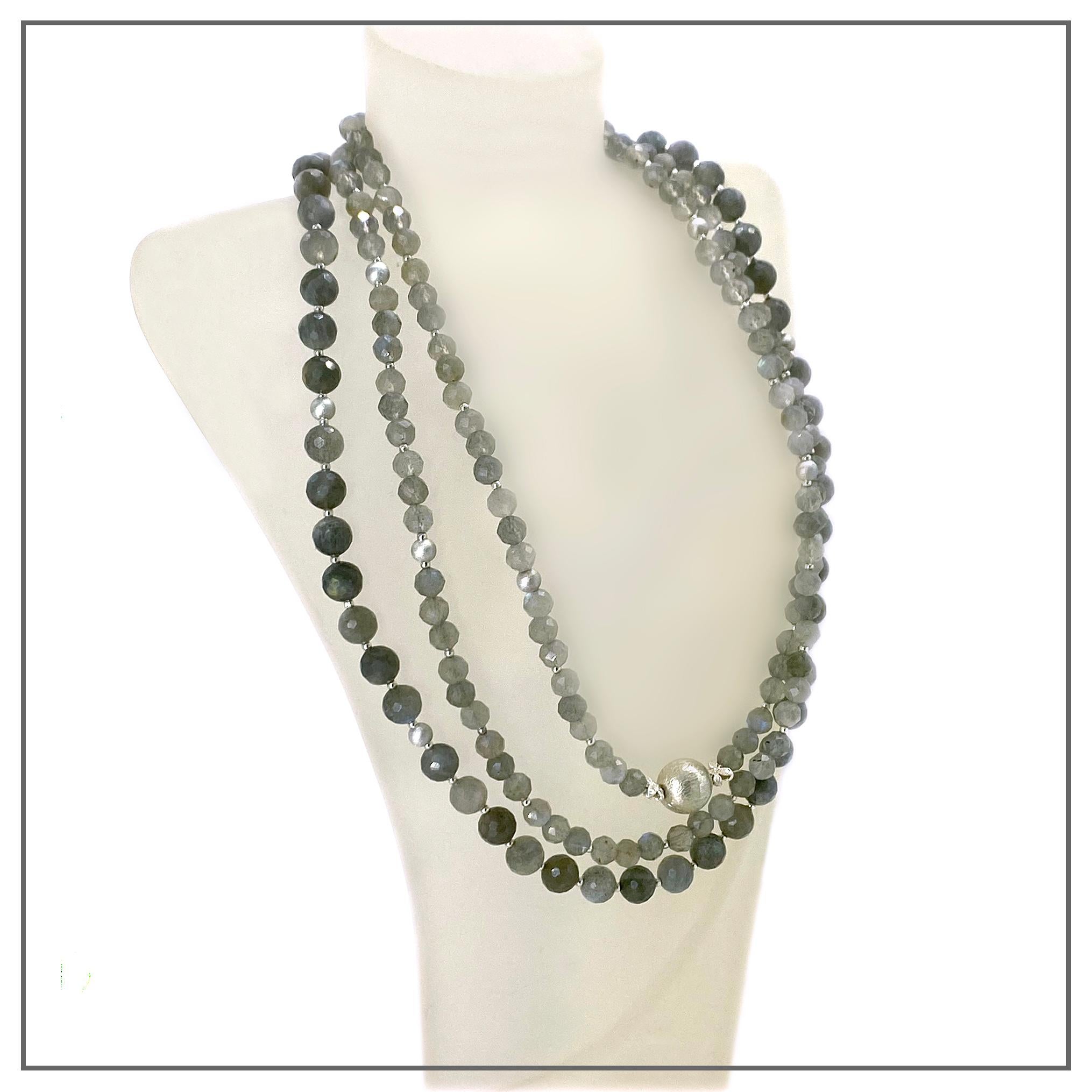 Se trata de un collar de labradorita de tres vueltas con componentes de plata de ley. La hemos creado con una ristra de cuentas de labradorita gris natural de 8 mm y dos de labradorita translúcida de 6 mm. Este brillante collar gris lleva una cuenta