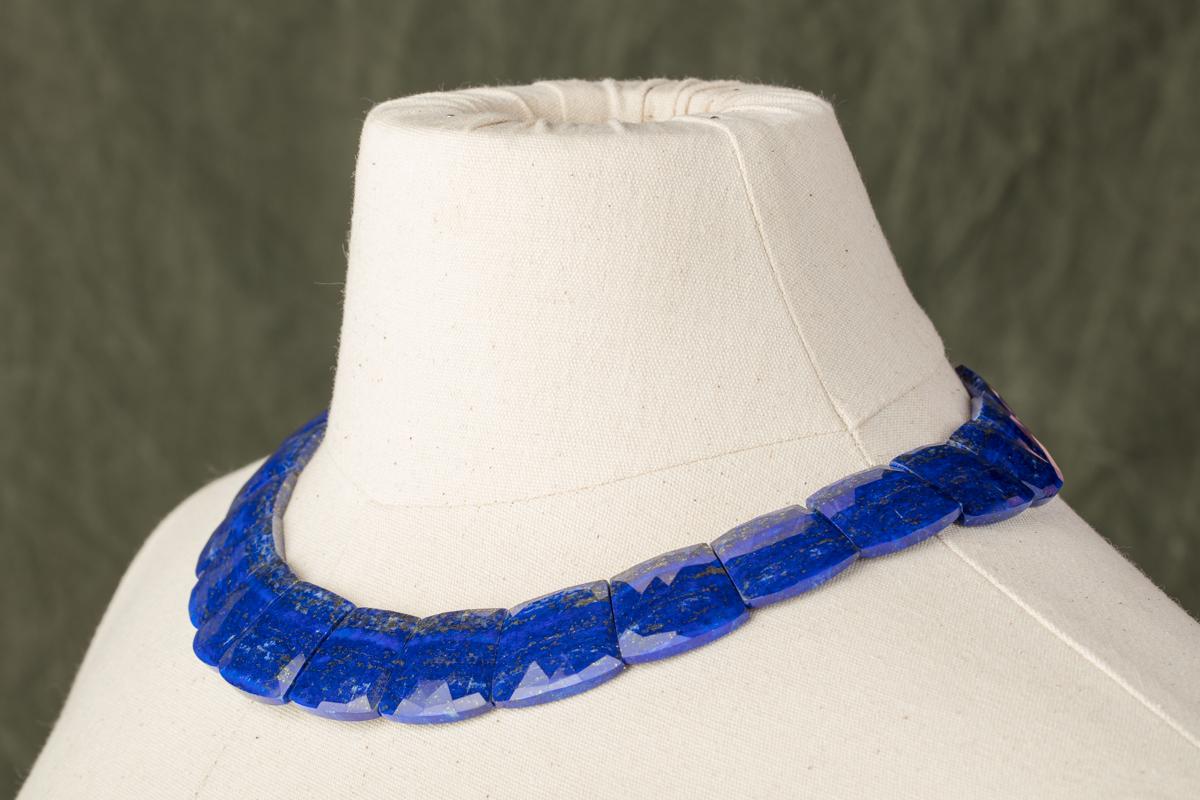Natural, large faceted lapis lazuli necklace with flecks of pyrite, as it should have.  Fabulous color and quality and a very unusual cut.  Flat stones against the skin and facets along the top.  Slightly graduated.  Sterling silver lobster claw