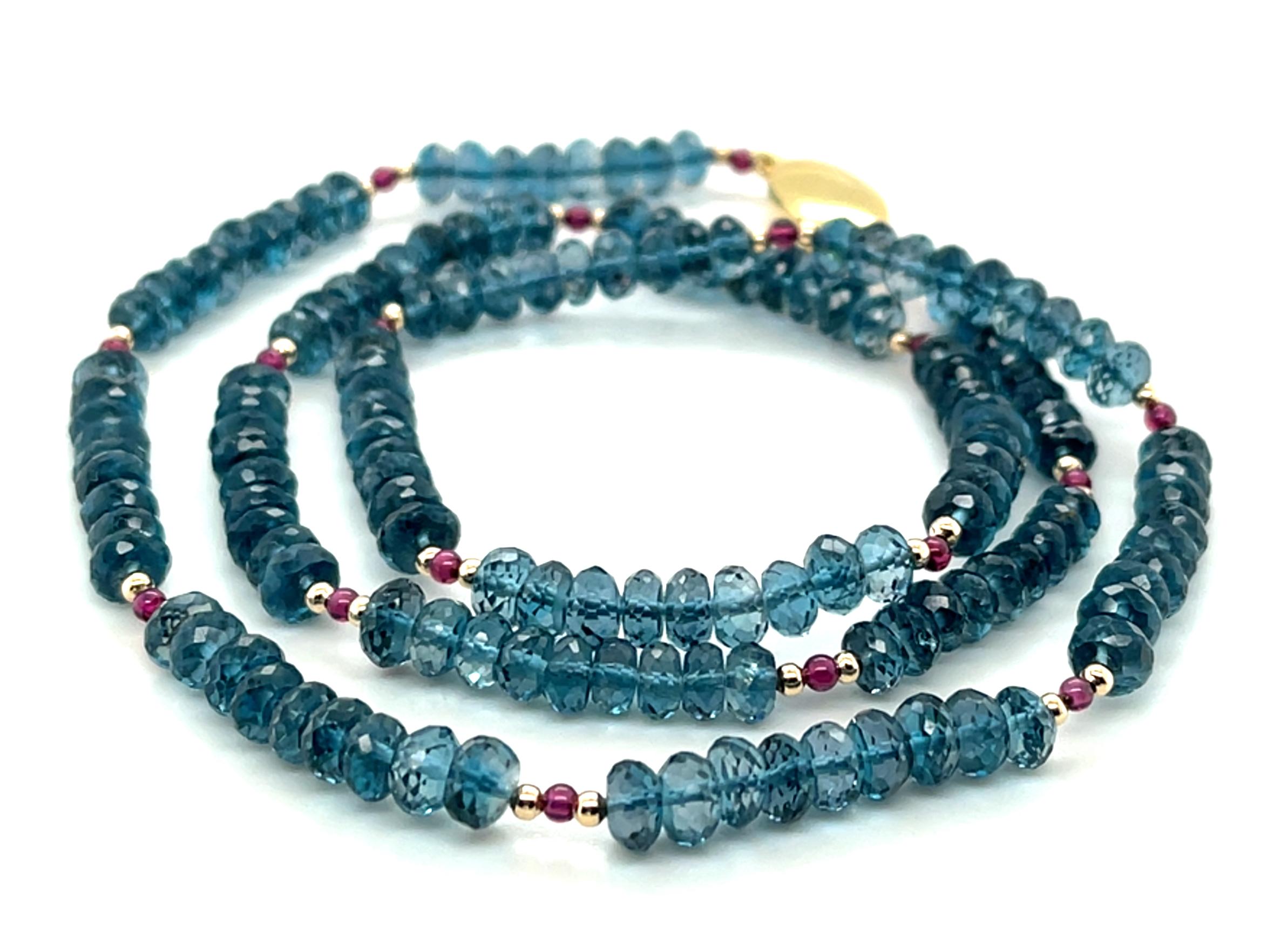 Ce collier polyvalent présente des perles de topaze bleue de Londres étincelantes, accentuées par de riches grenats rouges et de l'or jaune 14k ! Les rondelles de topaze bleue de 5 mm sont magnifiquement facettées, ce qui leur permet de révéler