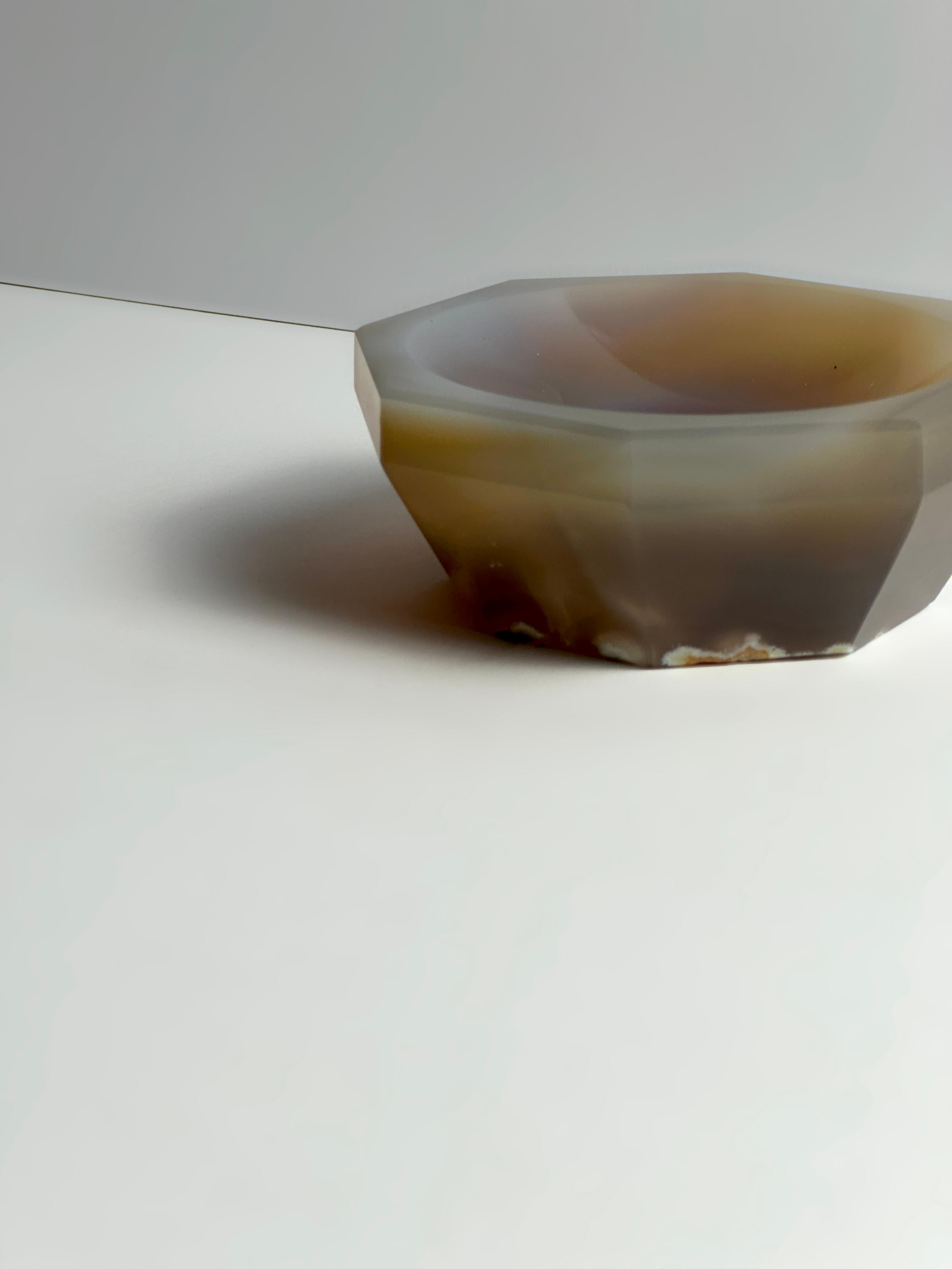 Este cuenco de ágata facetada de la década de 1960 es un objeto decorativo escultórico hecho con ágata natural de Botsuana, una forma muy apreciada de cristal de calcedonia en bandas conocida por su suave translucidez gris ahumada y sus bandas en
