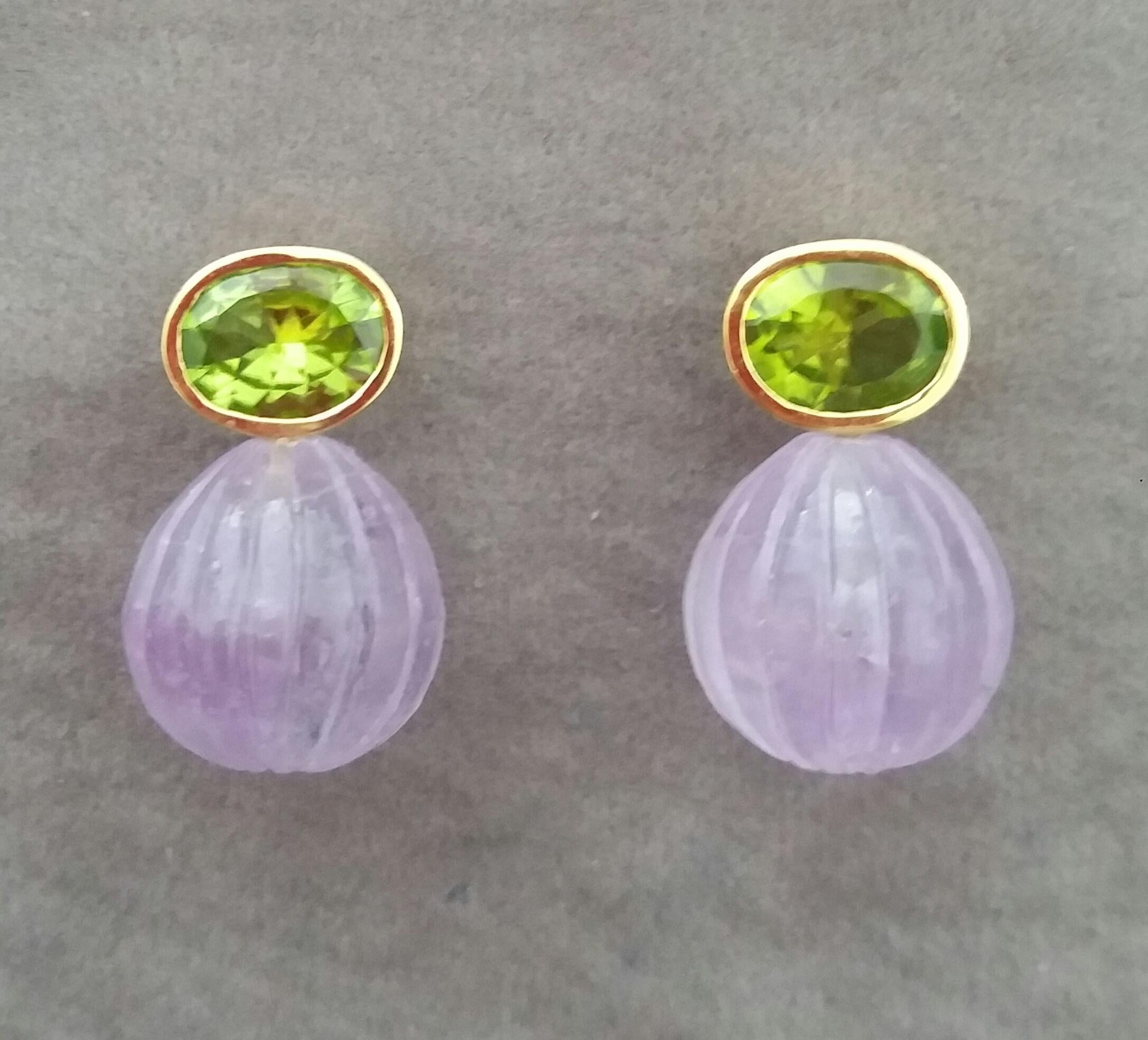 Diese einfachen, aber eleganten und einzigartigen Ohrringe haben 2 facettierte ovale Peridots mit den Maßen 9x11 mm  eingefasst in eine Lünette aus 14-karätigem Gelbgold, an der 2 runde Tropfen mit geschnitztem Amethyst von 15 x 15 mm hängen.

1978