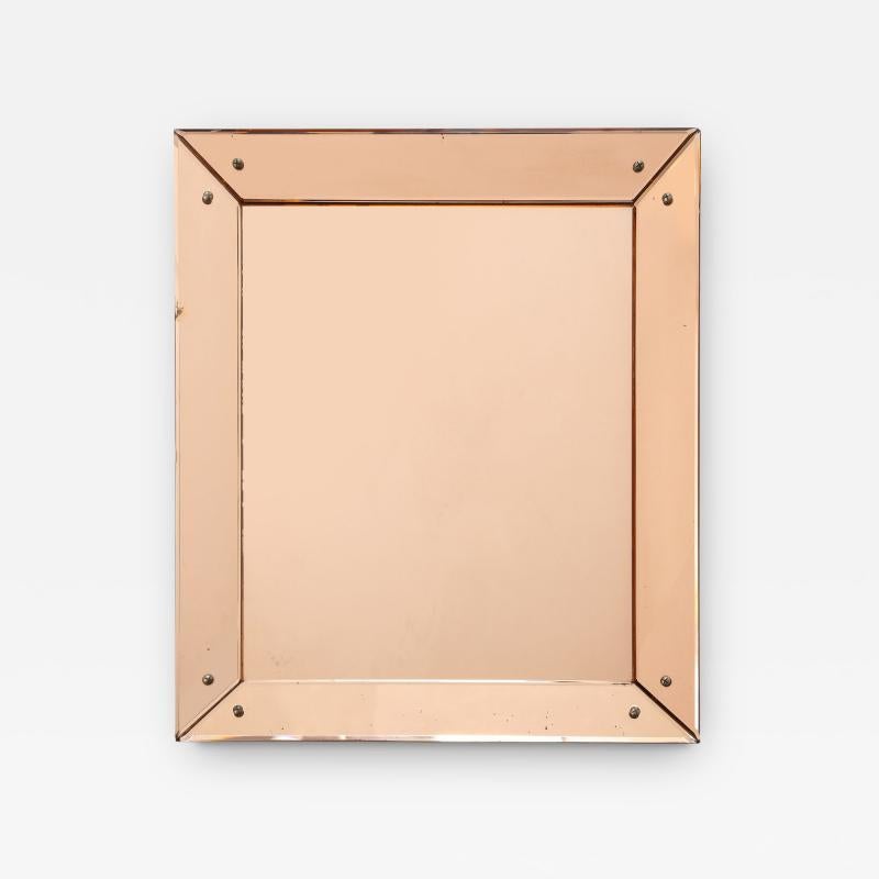 Refined peach-glass mirror. A beveled edge runs around the frame section of the mirror and steel screws at the corners highlight the construction of the form; subtle design touches add to the overall effect of this elegant, unique mirror.

