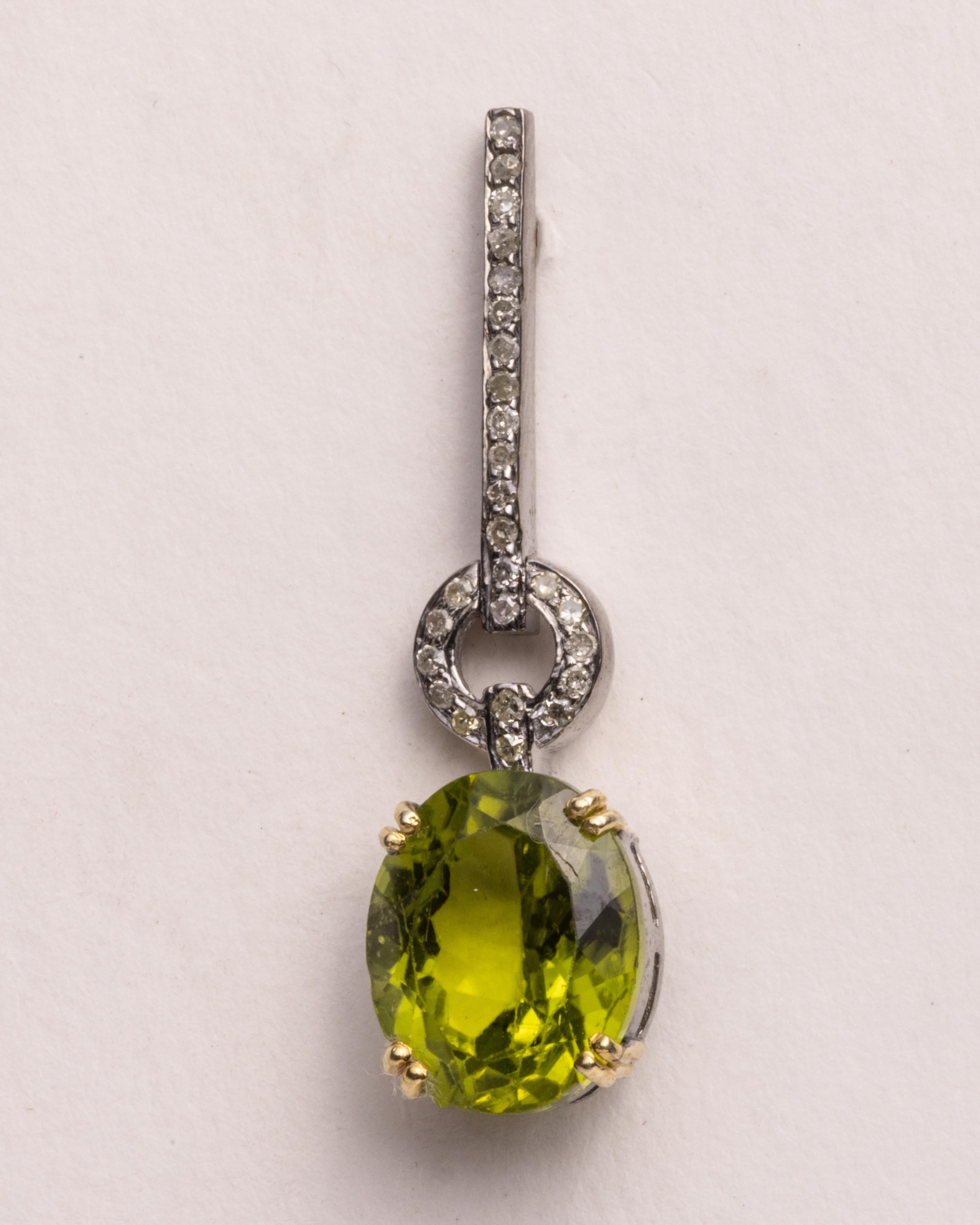 A lovely pair of drop earrings with large, faceted oval peridot gemstones with round, brilliant cut diamonds in a pave` 8..setting in sterling silver.  18K gold post for pierced ears.  Carat weight of peridot stones total 8.55 carats.  Diamonds