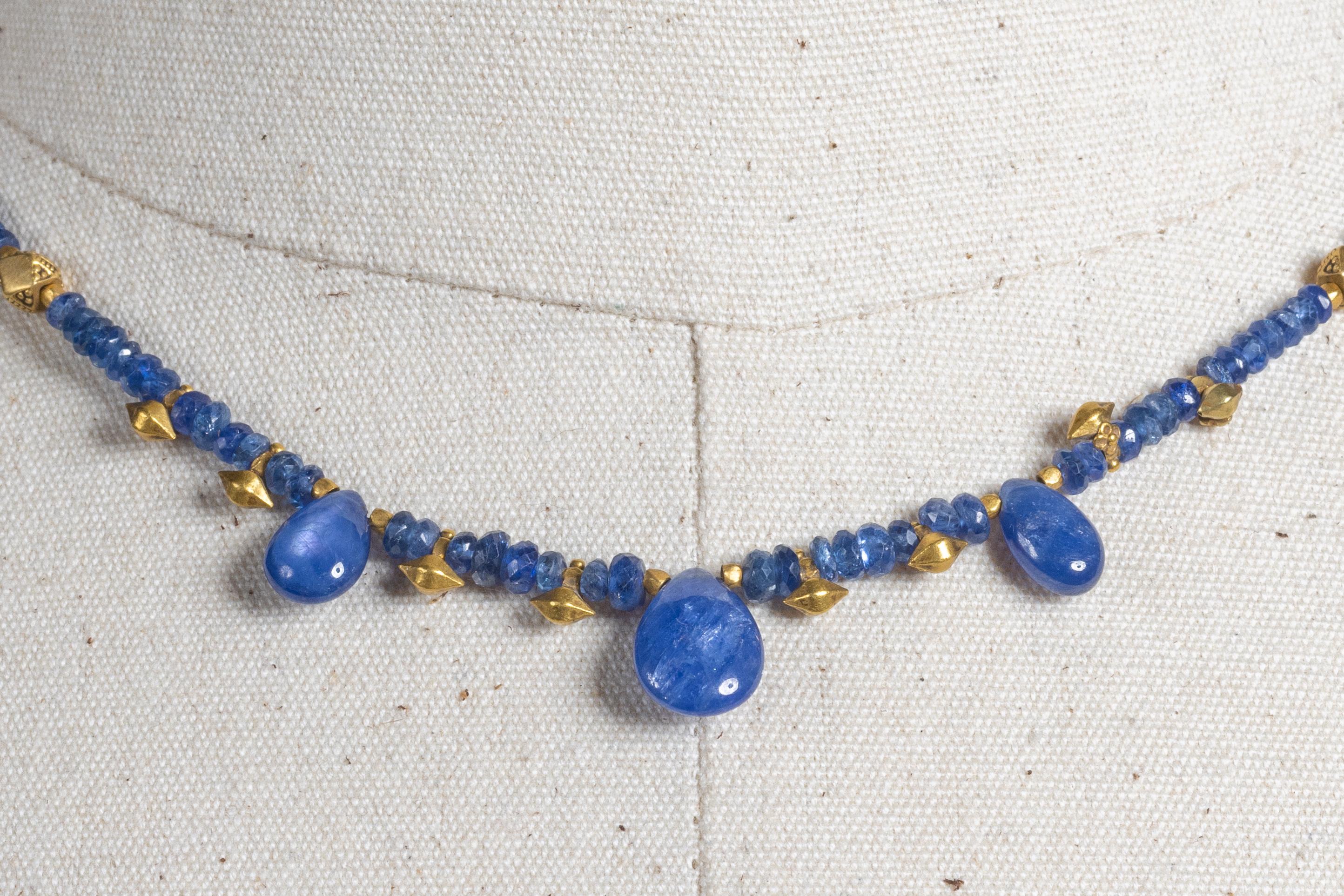 A striking yet delicate necklace comprised of faceted blue sapphire beads with three pear shaped drops at the front.  Spaced with 22K gold beads and an S-hook clasp.  There is added chain at the back to allow the length to adjust from 16