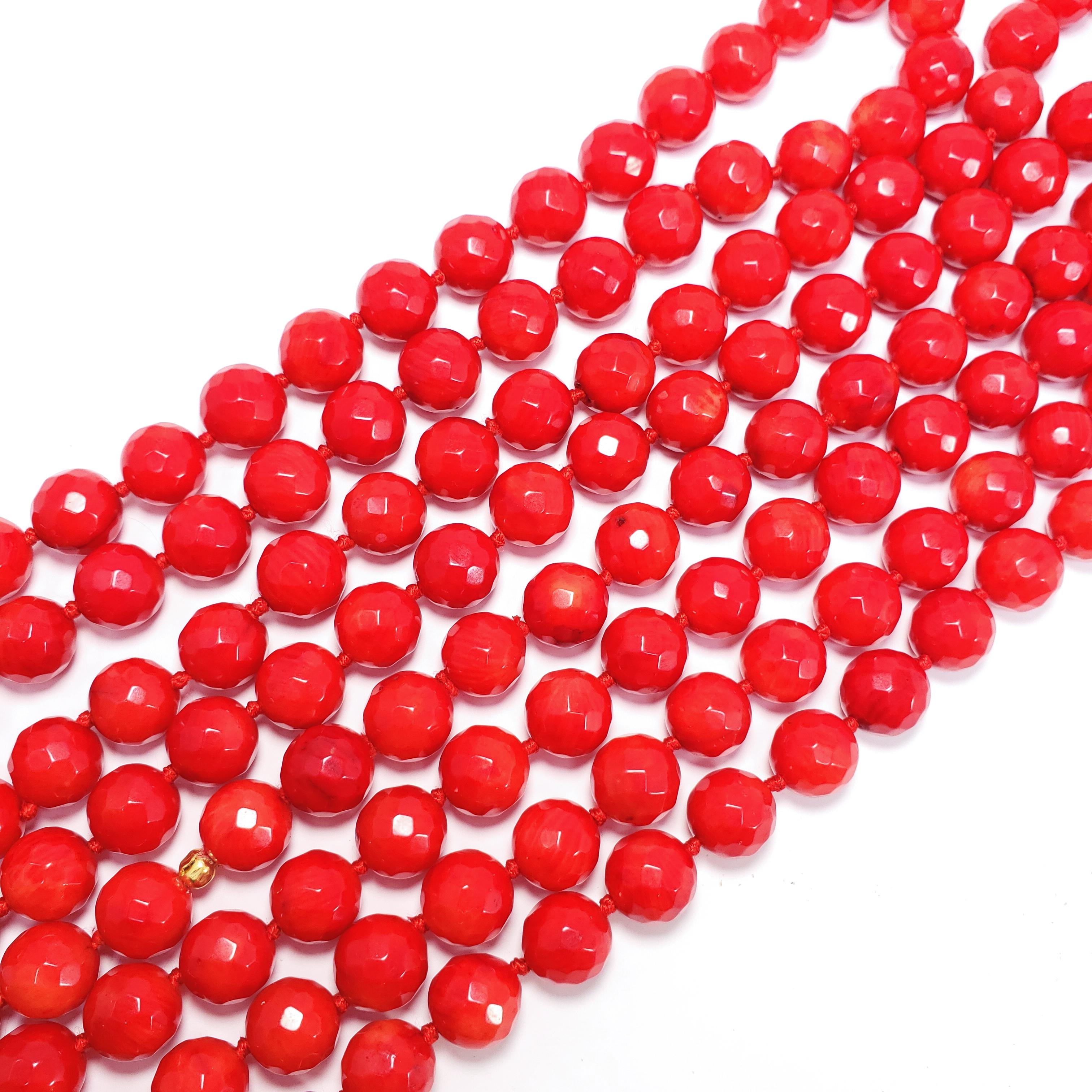 A gorgeous, bright-red coral necklace featuring faceted sea coral beads on a matching knotted red string, accented with a single yellow gold motif. This necklace is an impressive 70 inch/178 cm around. A striking yet versatile accessory perfect for
