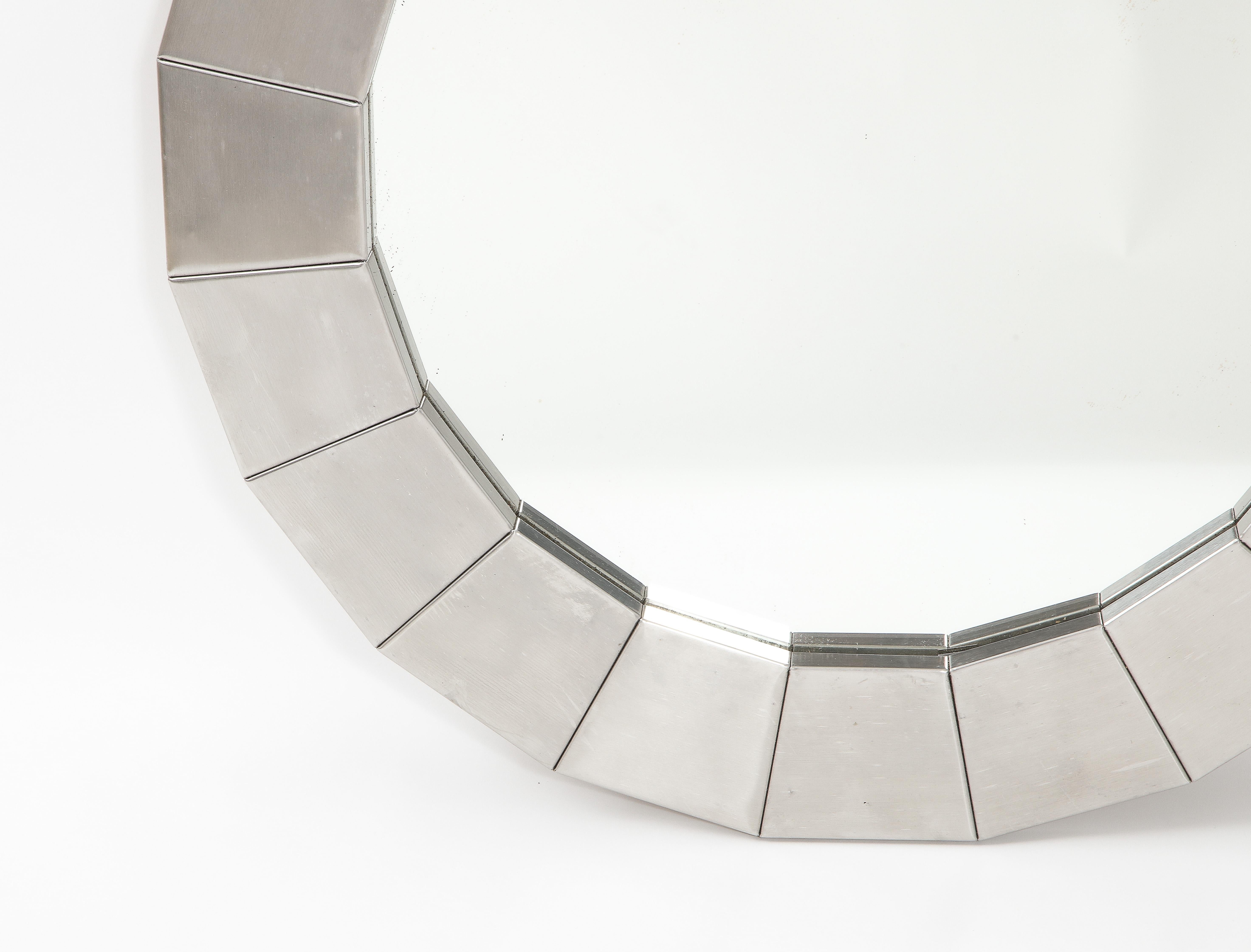 Stainless steel mirror with a faceted construction.