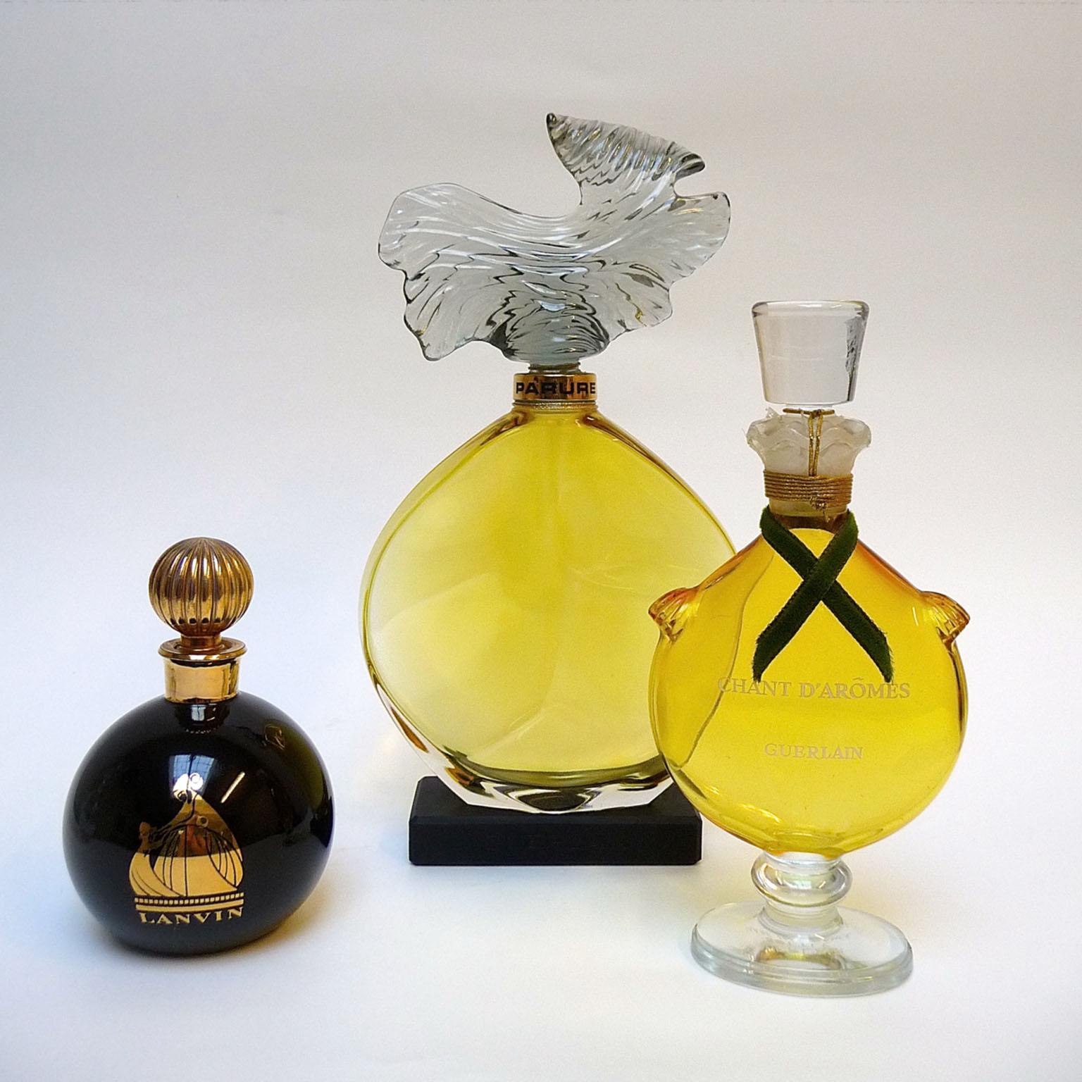 Factice Parfüm Guerlain Lanvin Geschäft Display Flaschen
Drei Parfümflakons aus einem Vintage-Laden, alle in ausgezeichnetem Zustand.
Von links nach rechts:
- Arpege Lanvin H 10 cm, schwarzer, kugelförmiger Flakon, bekannt als Boule Noire, dieser
