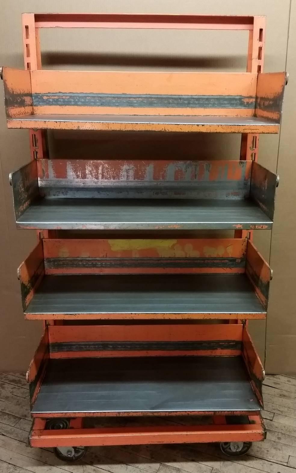 Straight from the factory floor in original colors. Cleaned, sealed and room ready, this early A-frame shelving unit adds style and storage to any room. Can also be used as a bookcase. Easily adjustable bin shelves with handles. Casters allow it to