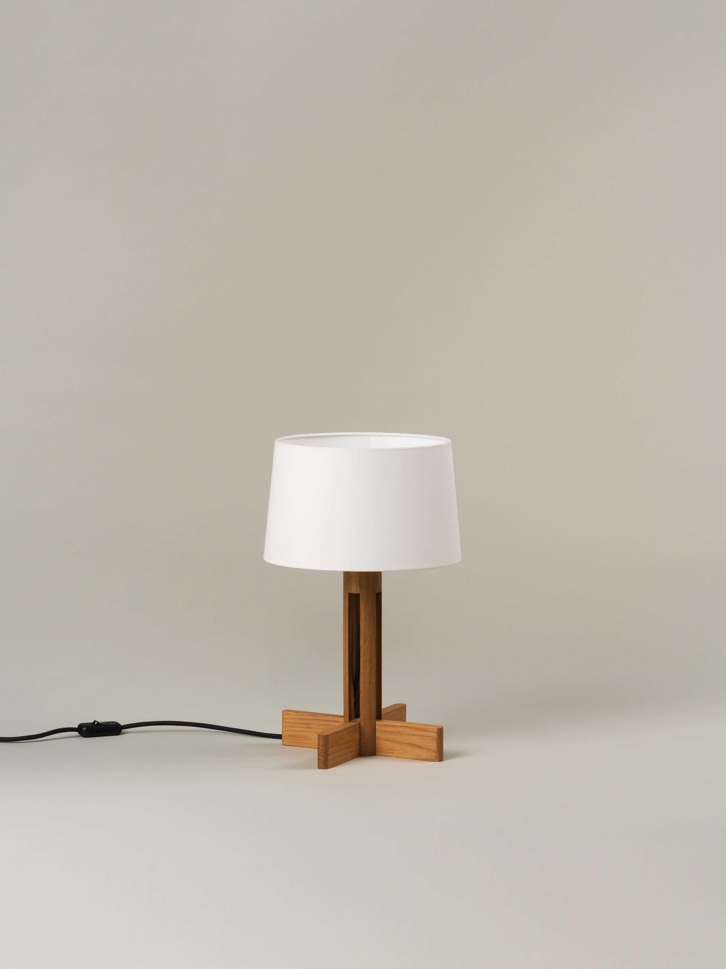 FAD Menor table lamp by Miguel Milá
Dimensions: D 26 x H 42 cm.
Materials: Linen, oak wood.

Miguel Milá got everything right compositionally with this demonstration of industrial craftsmanship. Its cylindrical oak column creates a vertical