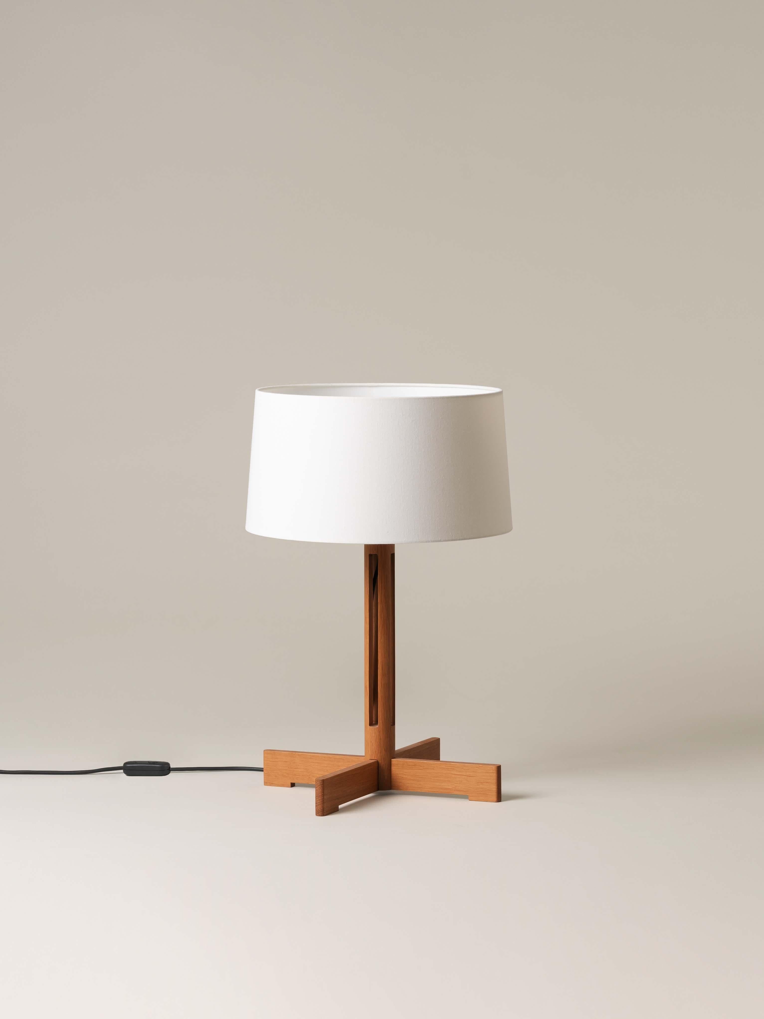 FAD table lamp by Miguel Milá
Dimensions: D 40 x H 61 cm
Materials: Linen, oak wood.

Miguel Milá got everything right compositionally with this demonstration of industrial craftsmanship. Its cylindrical oak column creates a vertical symmetry